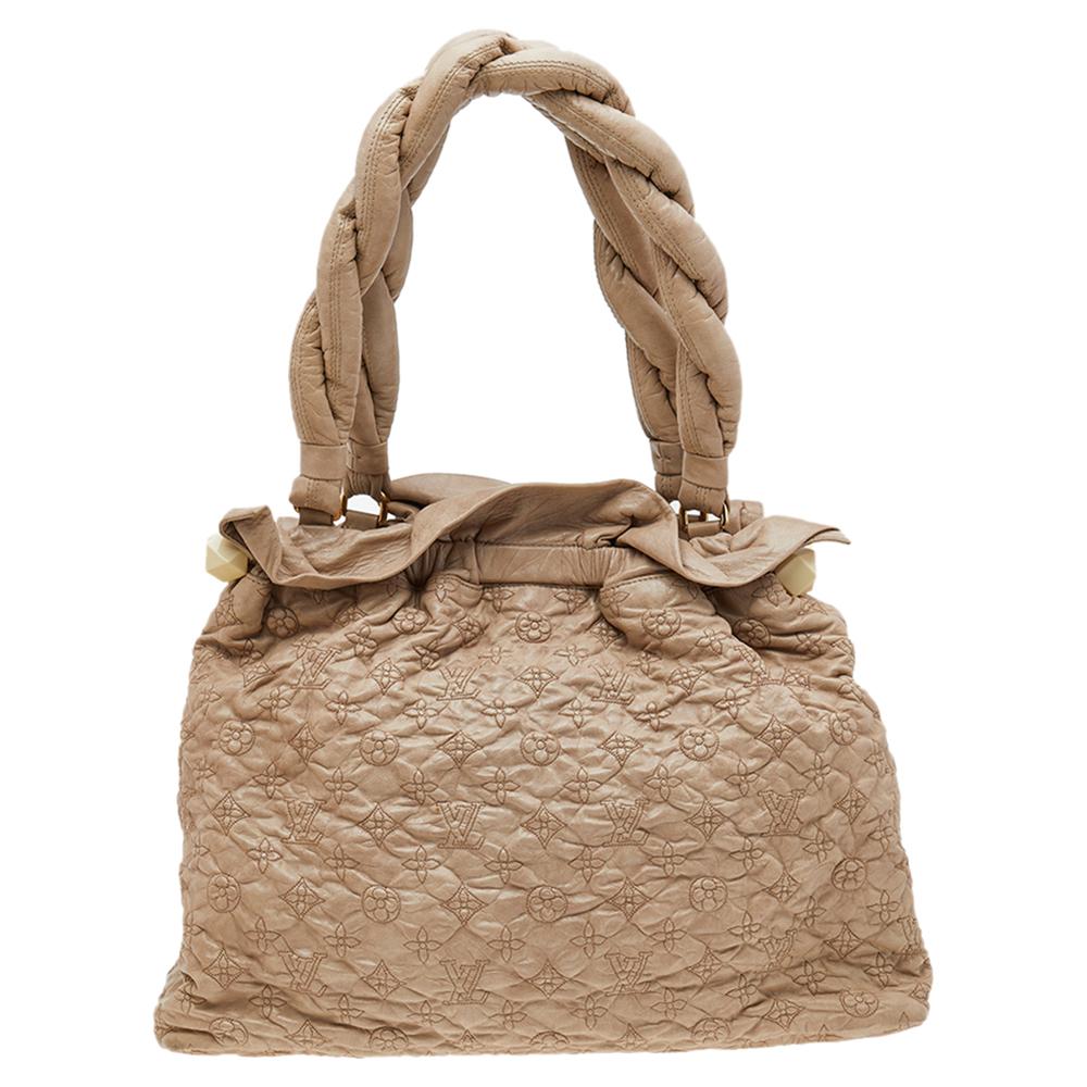 Part of a limited edition from Louis Vuitton, this Stratus Olympe GM bag is expertly crafted from beige monogram leather and features a ruched top. It comes with interesting braided top handles and is aptly sized to hold just essentials. Carry it to