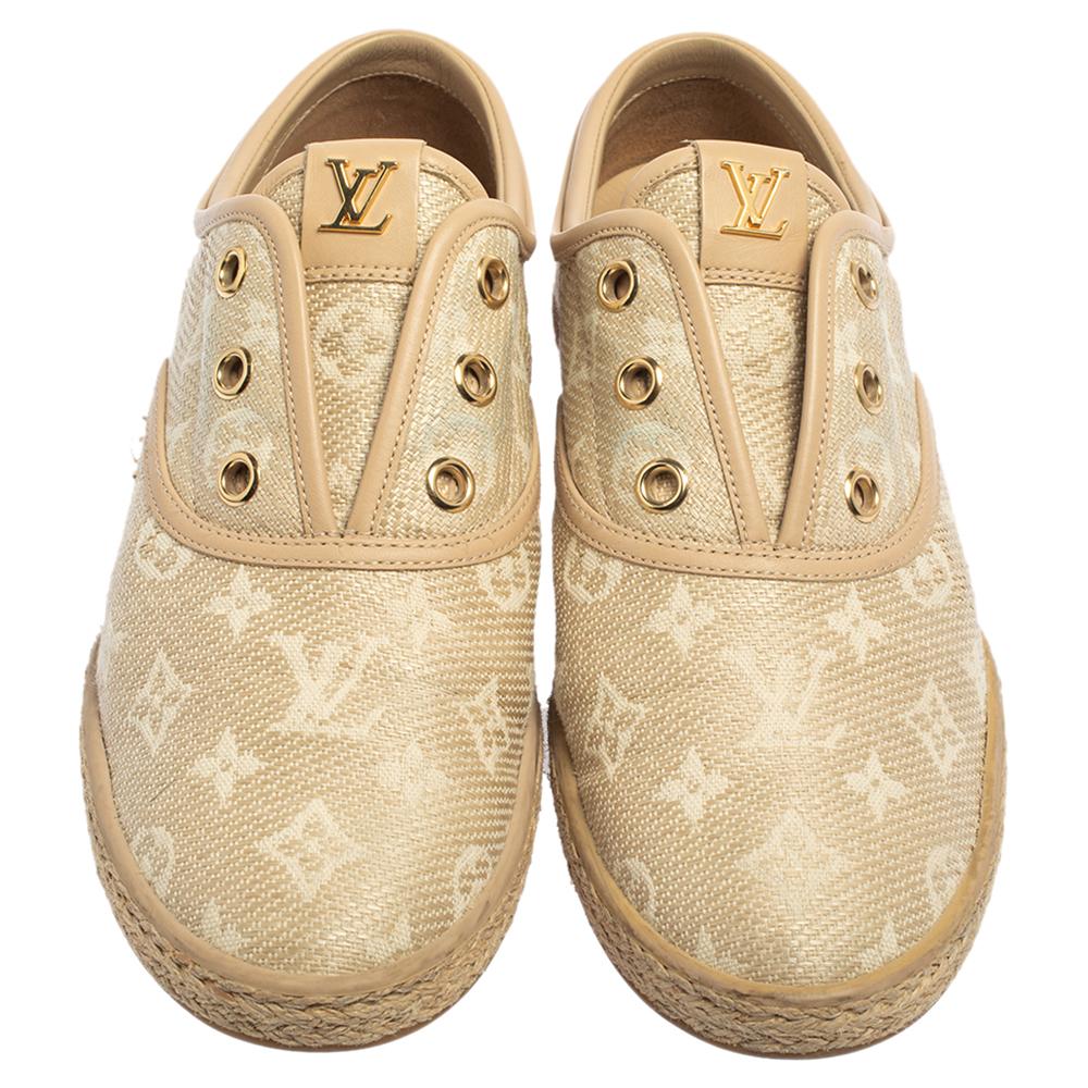 Make an amazing style statement in these slip-on sneakers from Louis Vuitton. They have been crafted from monogram canvas and raffia and styled with round toes. They are adorned with gold-tone eyelets and brand logo details on the tongues and come