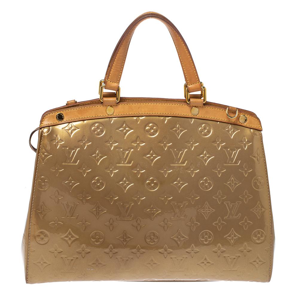 The feminine shape of Louis Vuitton's Brea is inspired by the doctor's bag. Crafted from Monogram Vernis leather in beige, the bag has a perfect finish. The fabric interior is spacious and it is secured by a zipper. The bag features double handles,