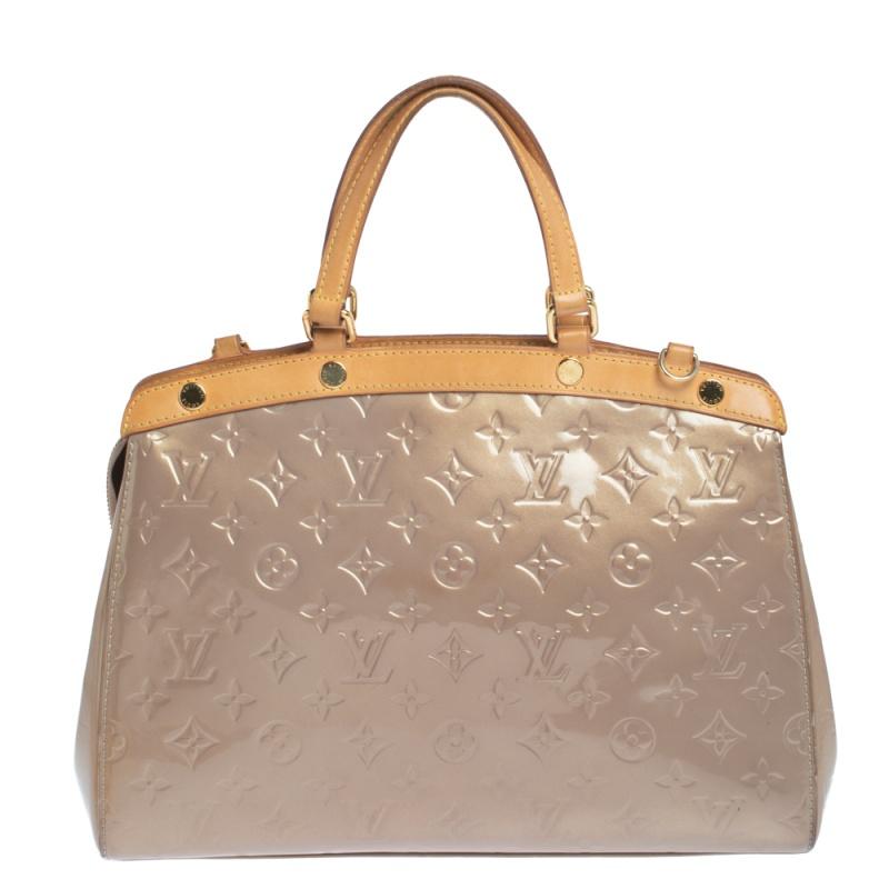The feminine shape of Louis Vuitton's Brea is inspired by the doctor's bag. Crafted from Monogram Vernis leather in beige, the bag has a perfect finish. The fabric interior is spacious and it is secured by a zipper. The bag features double handles,