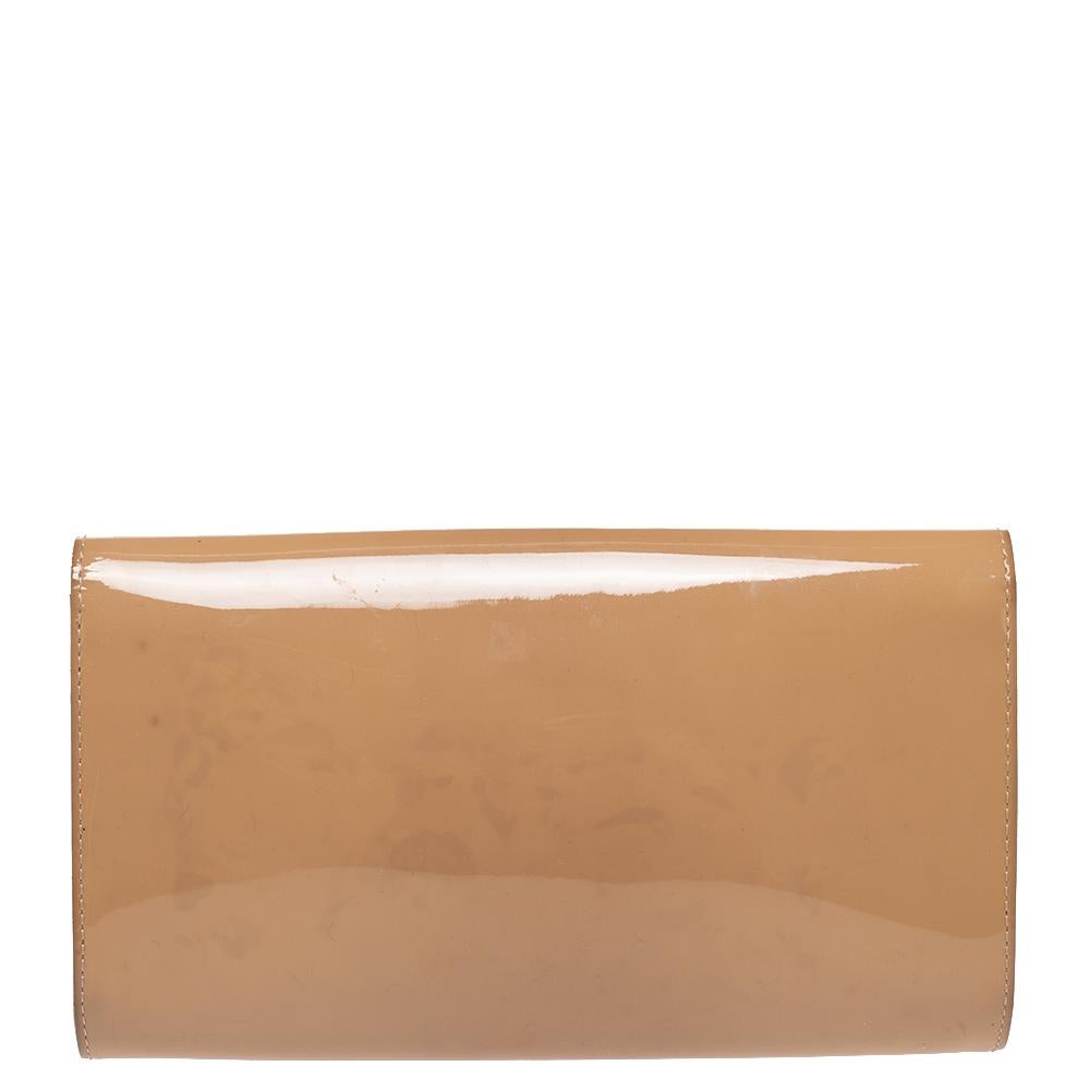 Diese beigefarbene Louise Clutch von Louis Vuitton ist gut verarbeitet und strotzt nur so vor Stil. Sie ist außen aus glänzendem Lackleder:: innen aus Leder und Stoff und mit einem großen goldfarbenen LV