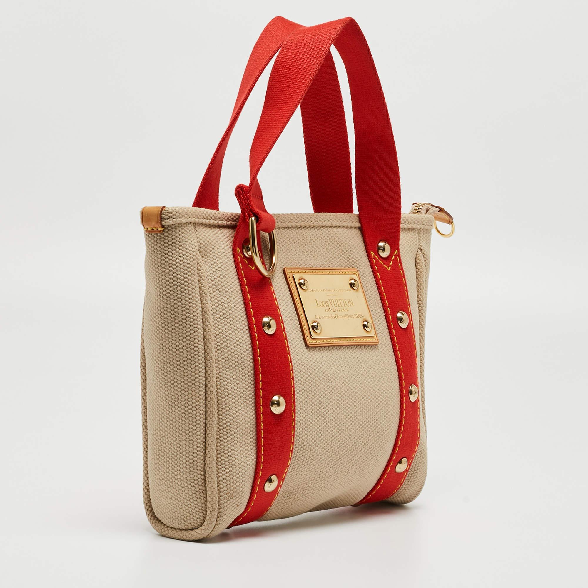 This durable bag by Louis Vuitton is easy to carry and is a blend of style and functionality. Add a touch of glam to your look with this beige and red bag. Crafted with canvas, this fun piece is perfect for the fashionista.


