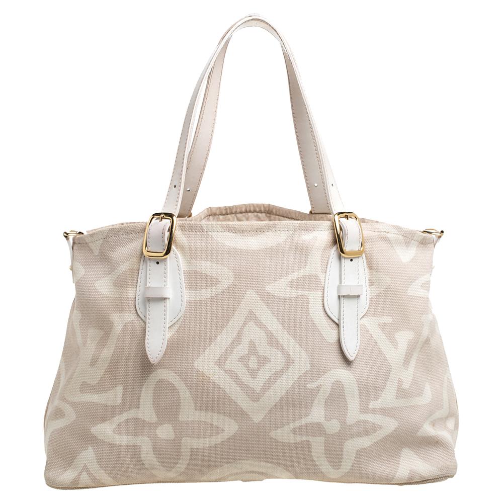 Questa creazione speciale è dedicata a tutti i collezionisti e agli amanti di Louis Vuitton. Realizzata meticolosamente in tela beige, questa borsa da sogno è sorretta da due manici con fibbie e decorata con una sottile interpretazione del Monogram