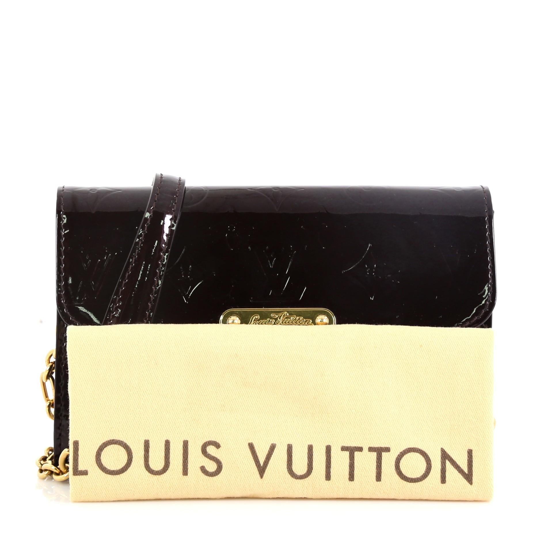 This Louis Vuitton Bel Air Pochette Monogram Vernis, crafted from purple monogram vernis leather, features a removable chain link shoulder strap with leather pad, and gold-tone hardware. Its magnetic snap button closure opens to a purple fabric