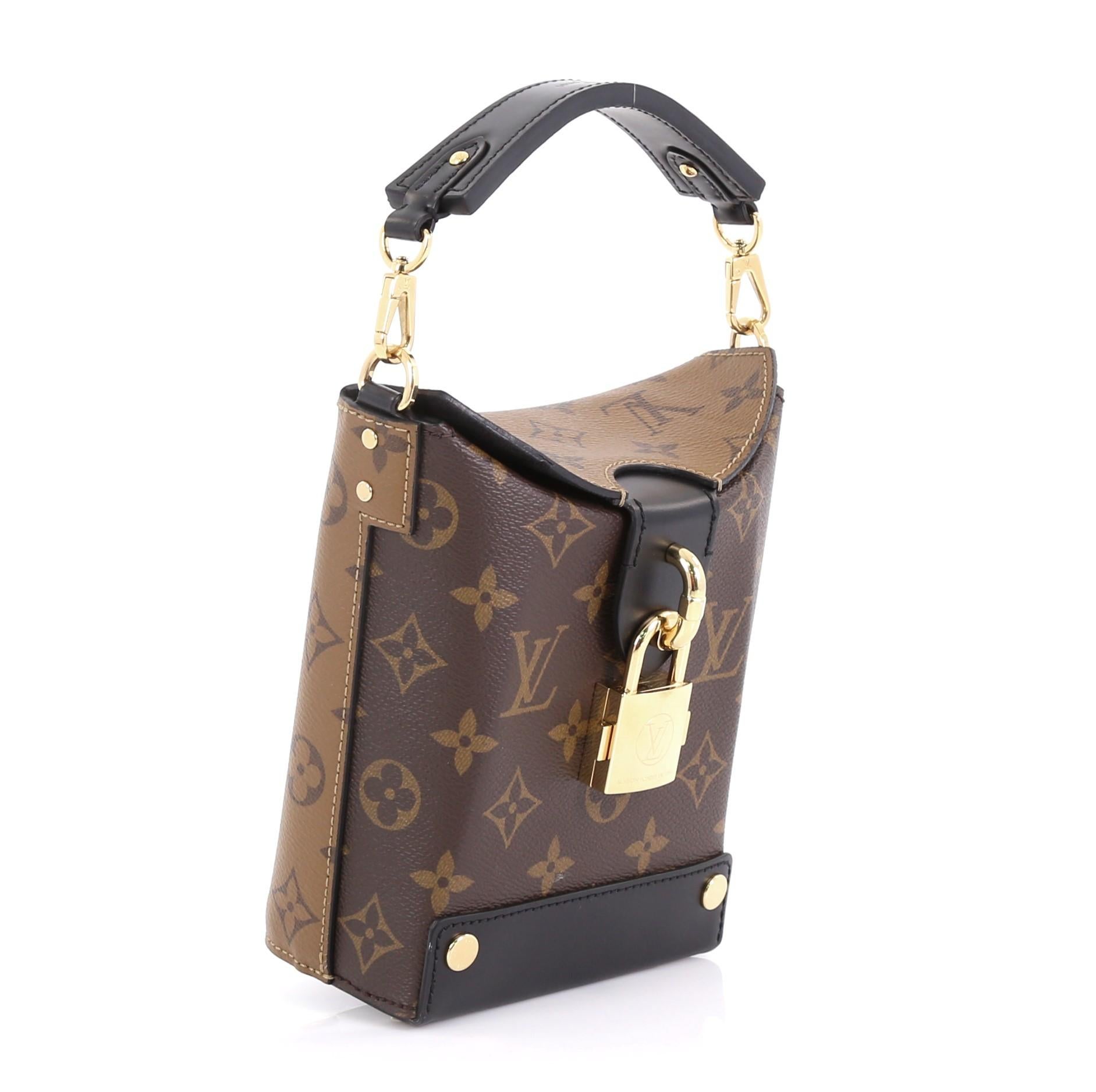 This Louis Vuitton Bento Box Handbag Reverse Monogram Canvas, crafted in brown monogram coated canvas on one side and reverse monogrammed coated canvas on the other, features a leather top handle, unique press padlock closure and gold-tone hardware.