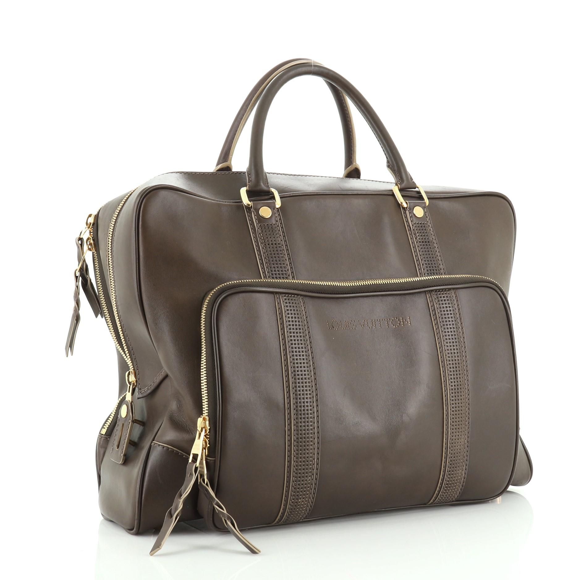 This Louis Vuitton Bequia 24 Hour Suitcase Bag Nomade Leather, crafted from brown nomade leather, features dual rolled handles, exterior front zip pocket and gold-tone hardware. Its zip closure opens to a neutral fabric interior. Authenticity code
