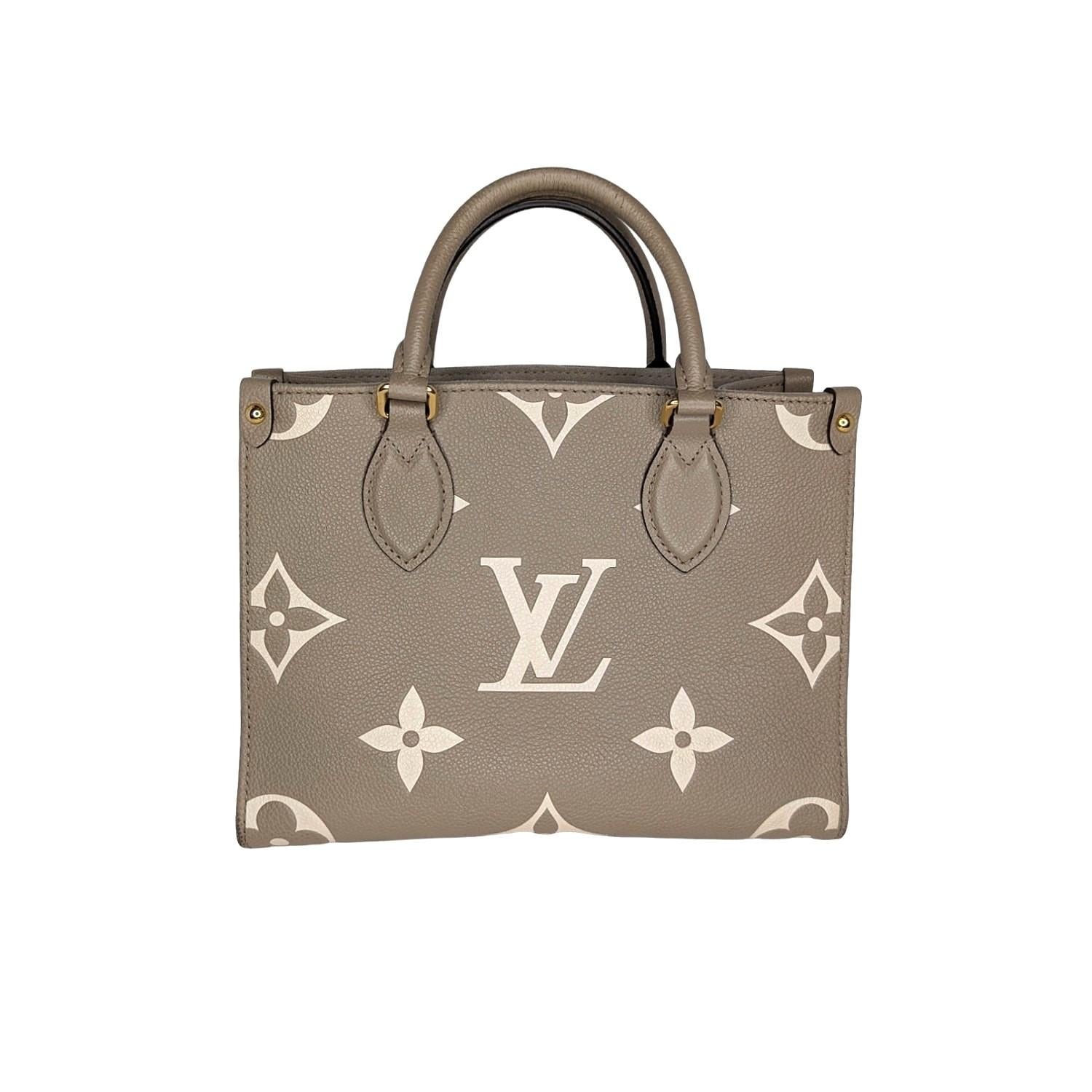 Louis Vuitton Empreinte Monogram Giant Onthego PM in Tourterelle Creme. This limited edition tote features oversized versions of the classic Louis Vuitton monogram leather in beige. The bag features beige leather top handles, an optional shoulder