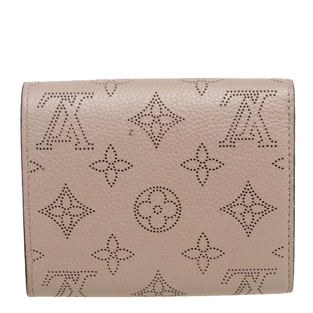 This Louis Vuitton Iris wallet is conveniently designed for everyday use. Crafted from Mahina leather, the wallet has a flap closure that opens to reveal multiple slots, leather-lined compartments, and a zip pocket for you to neatly arrange your