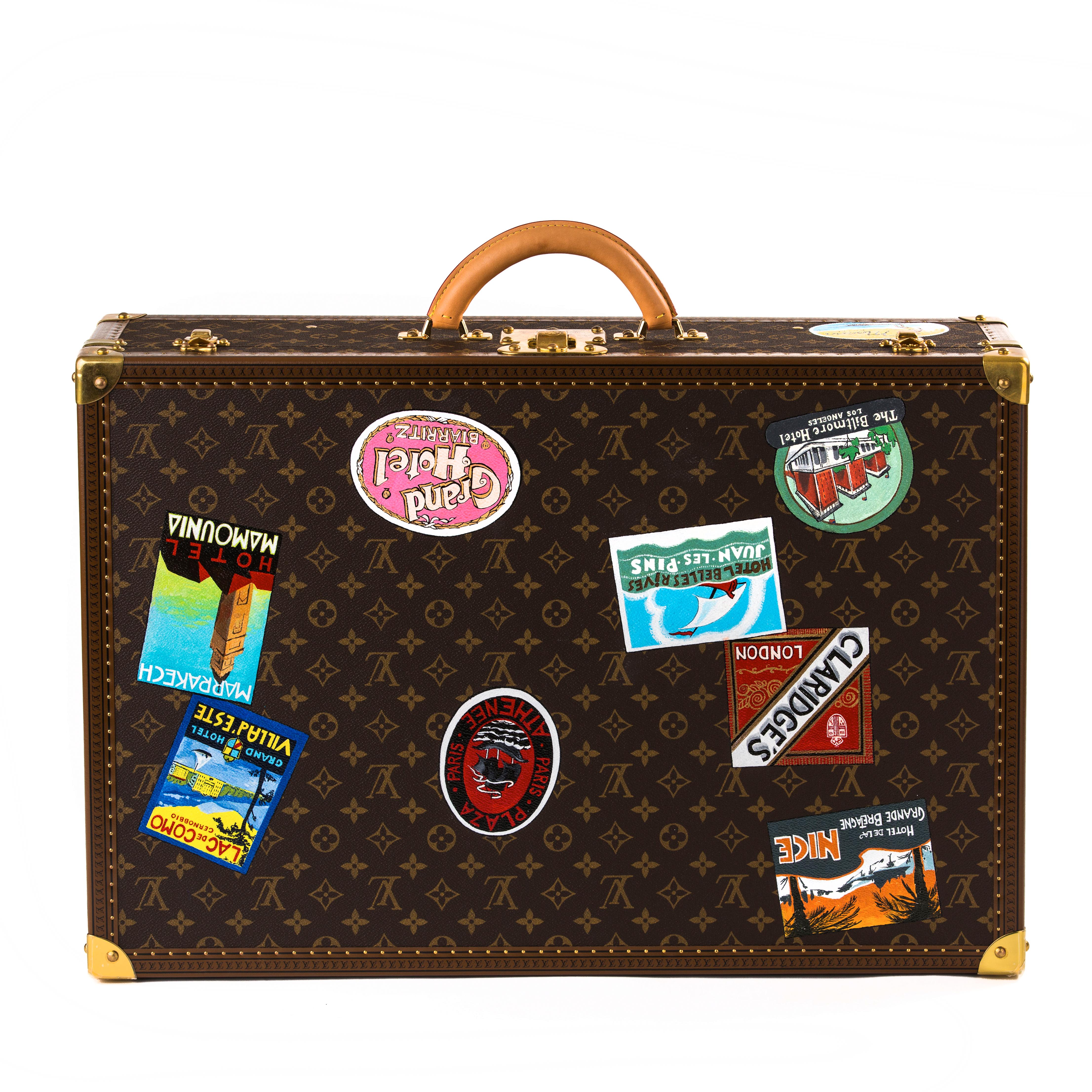 Louis Vuitton Bisten suitcase 

Exclusively painted for Palmer & Penn in Beverley Hills.
This is a one off item.
Beautifully decorated with travel stickers showcasing leading hotels in the world.
 