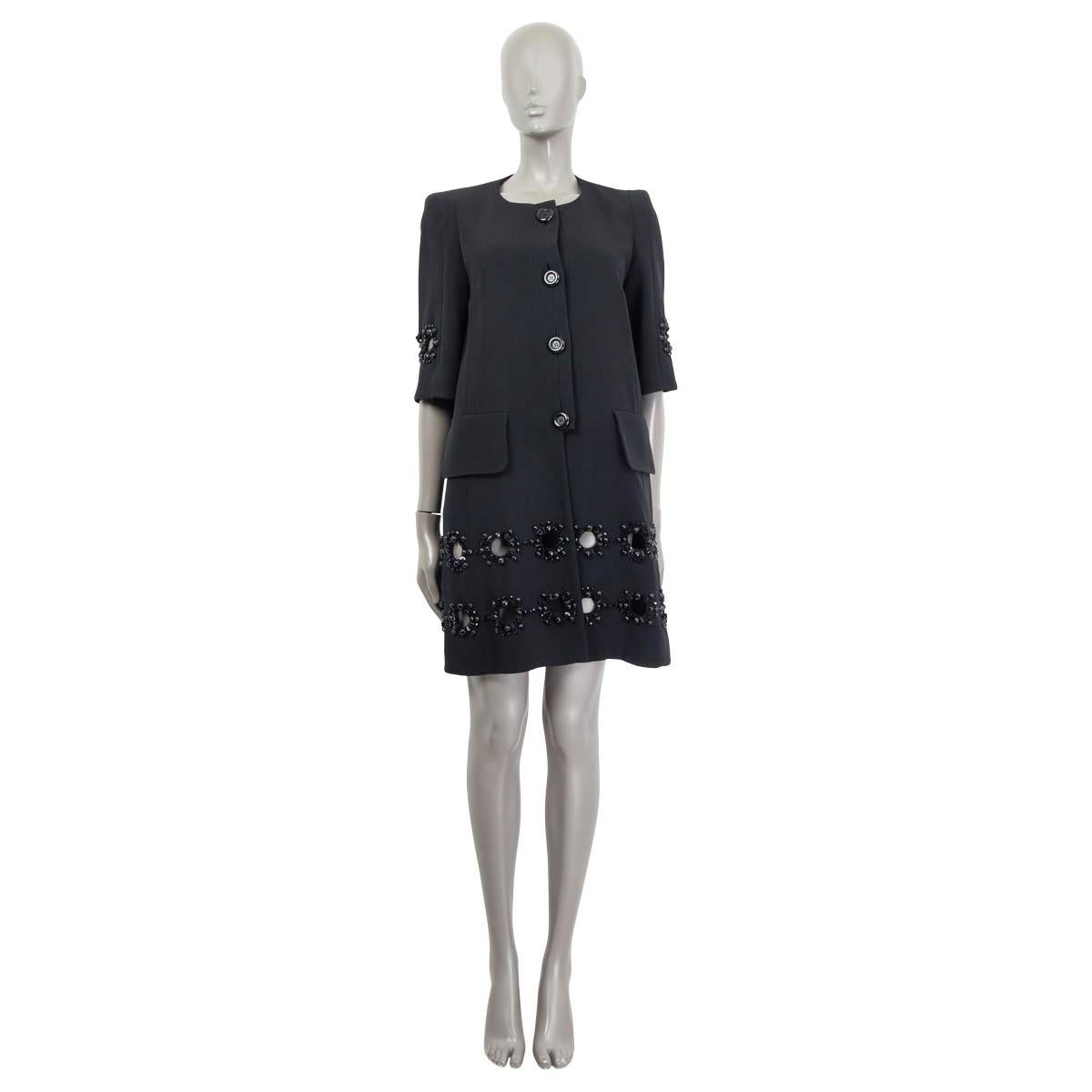100% authentic Louis Vuitton collarless 3/4-sleeve long jacket in black acetate (58%) and viscose (42%). With two front flap pockets and circle cutouts framed by black beads. Closes with large black buttons on the front. Lined in black cupro (50%)