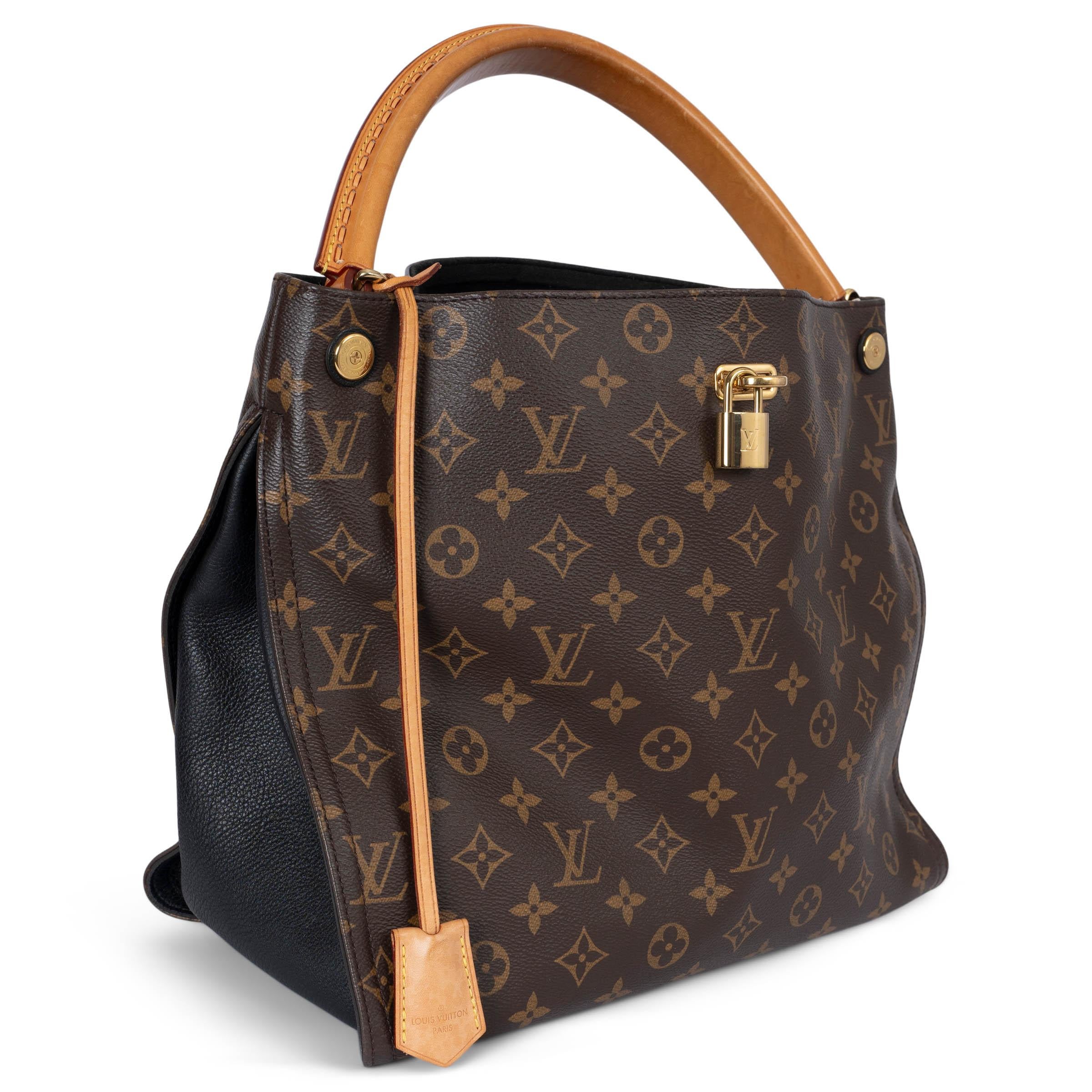This 100% authentic Louis Vuitton Gaia hobo bag is crafted from classic Ebene brown Monogram canvas with black leather gussets and trims, complemented by a natural vachetta handle for a refined, luxurious look. The bag features a convenient front