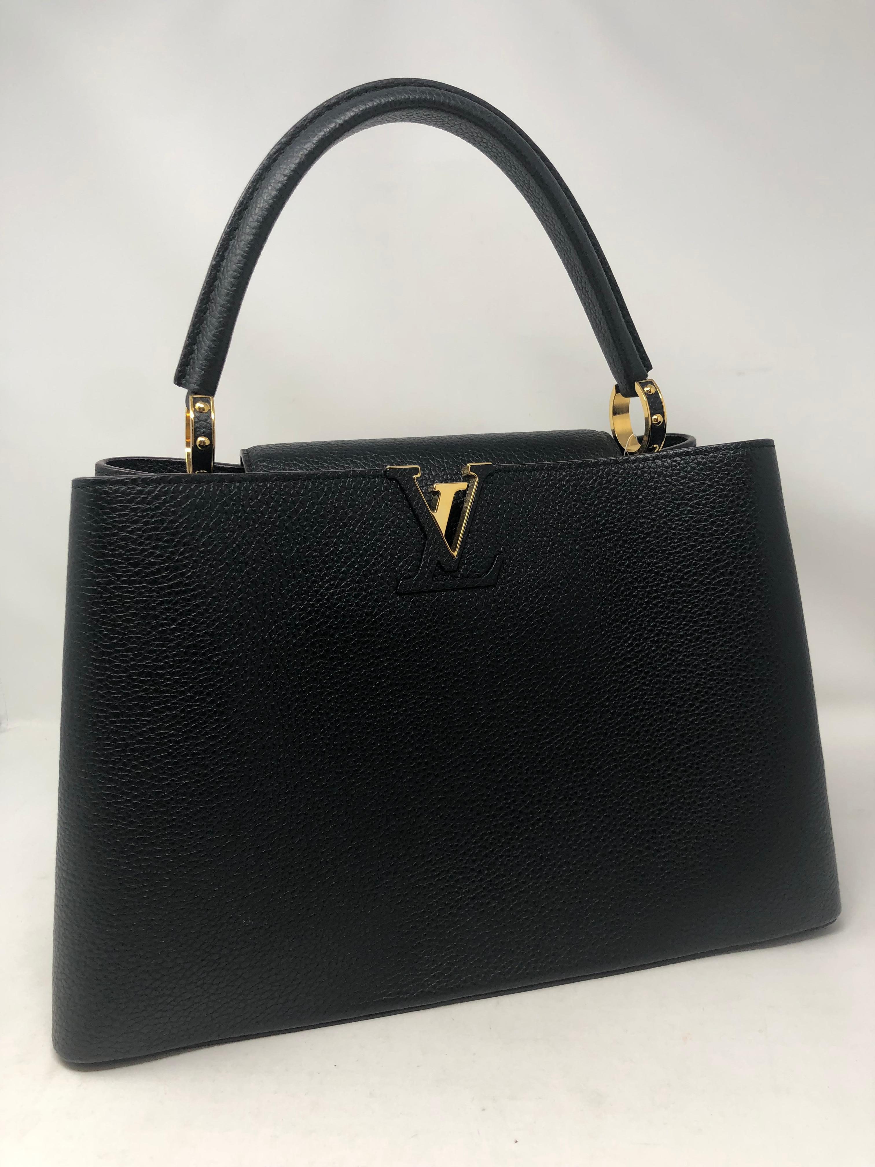 Louis Vuitton Black Capucines MM Bag. Black taurillon leather is like brand new condition. Beautiful raspberry leather lining is clean too. LV Logo accent on front face and can be covered with additional top closure. The fleur LV flower logo is on