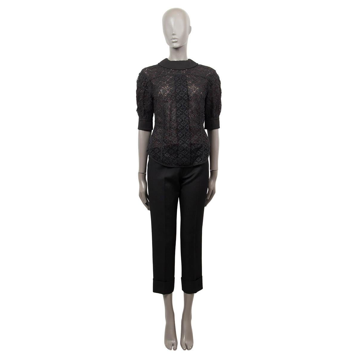 100% authentic Louis Vuitton short sleeve crochet top in black cotton (87%) and polyester (13%). Features a collared neck and big black buttons on the back. Opens with push buttons on the back. Lined in brown tulle silk (100%). Has been worn and is