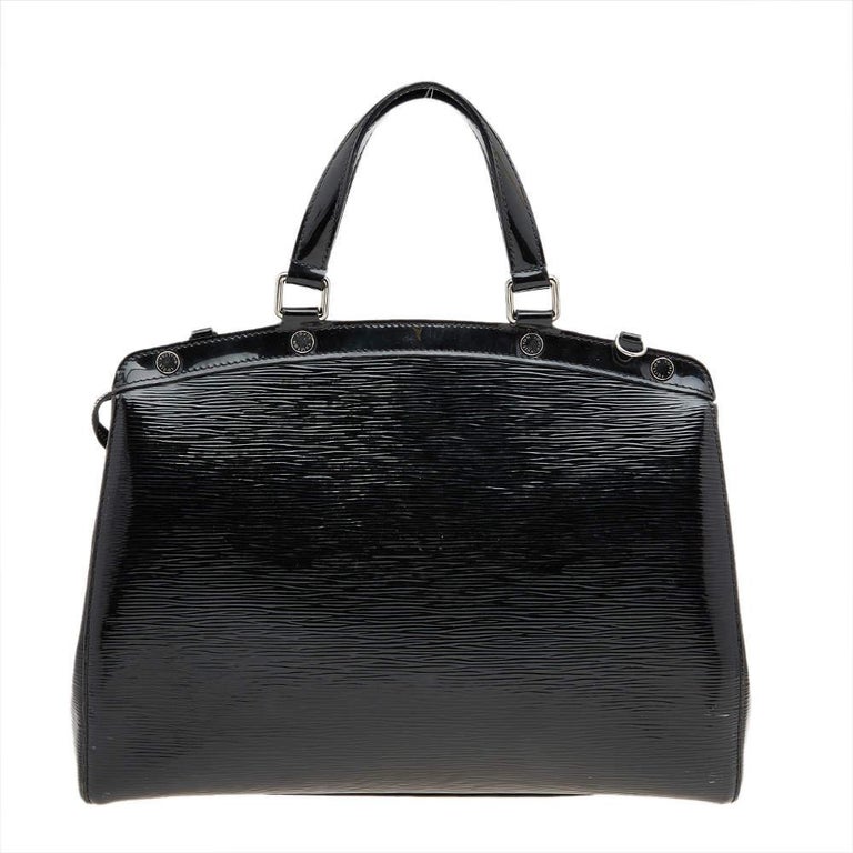 This Brea GM bag from the House of Louis Vuitton will definitely sway you away with its precise shape, style, and design. It is made from black Electric Epi leather into a structured, neat silhouette. It flaunts silver-toned fittings, dual top