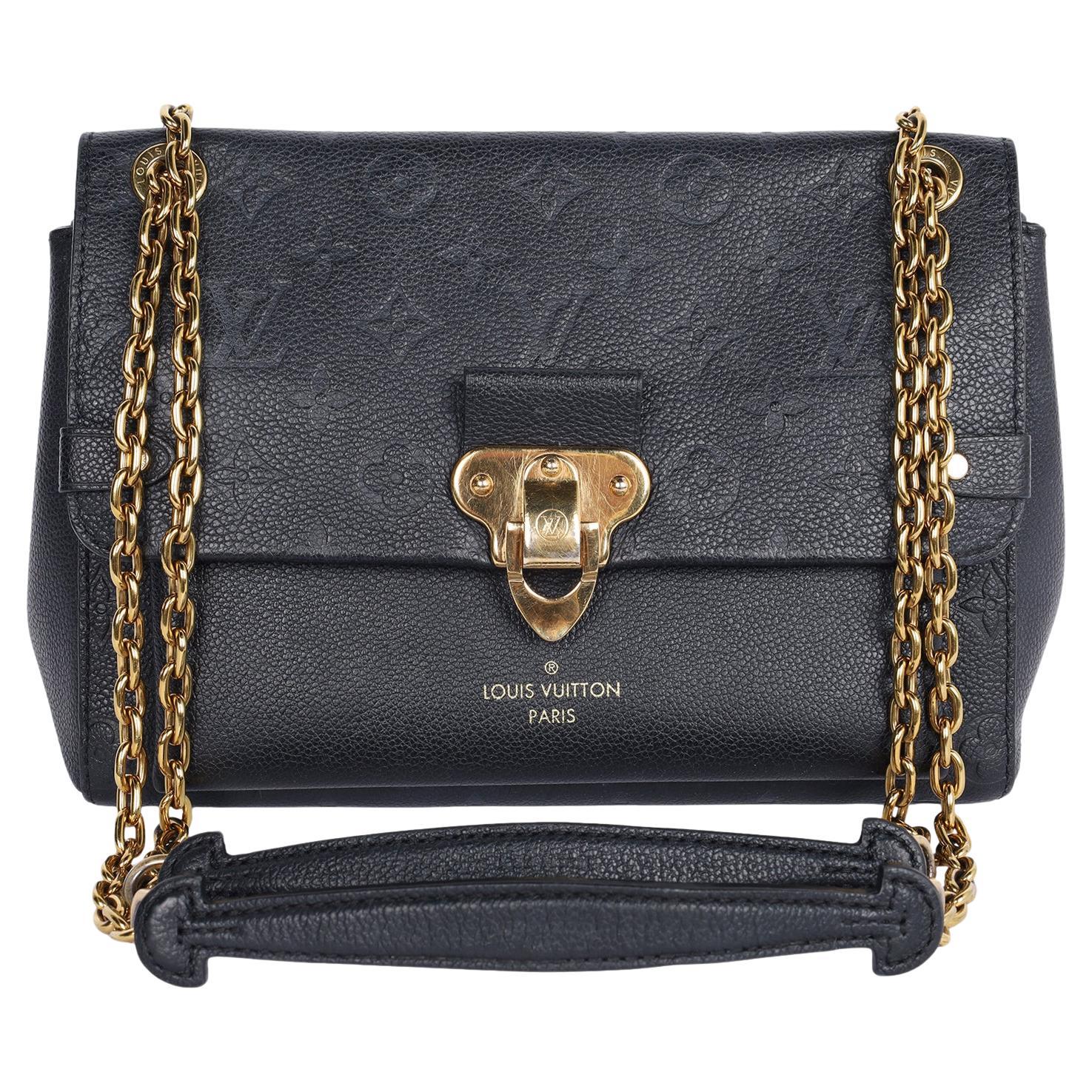 Authentic, pre-loved Louis Vuitton Black Vavin PM in Empreinte Leather. This beautiful front flap style shoulder bag features Louis Vuitton monogram embossed Empriente leather in black, brass hardware, bijoux chain link and leather strap, magnetic