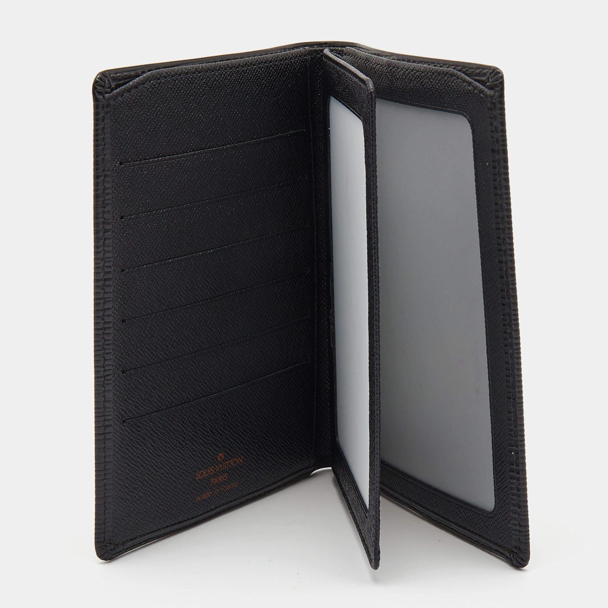 The Louis Vuitton document holder is a luxurious accessory crafted from textured black Epi leather. It features a sleek bifold design with multiple card slots and compartments to organize documents, cards, and cash. The iconic LV logo subtly adorns
