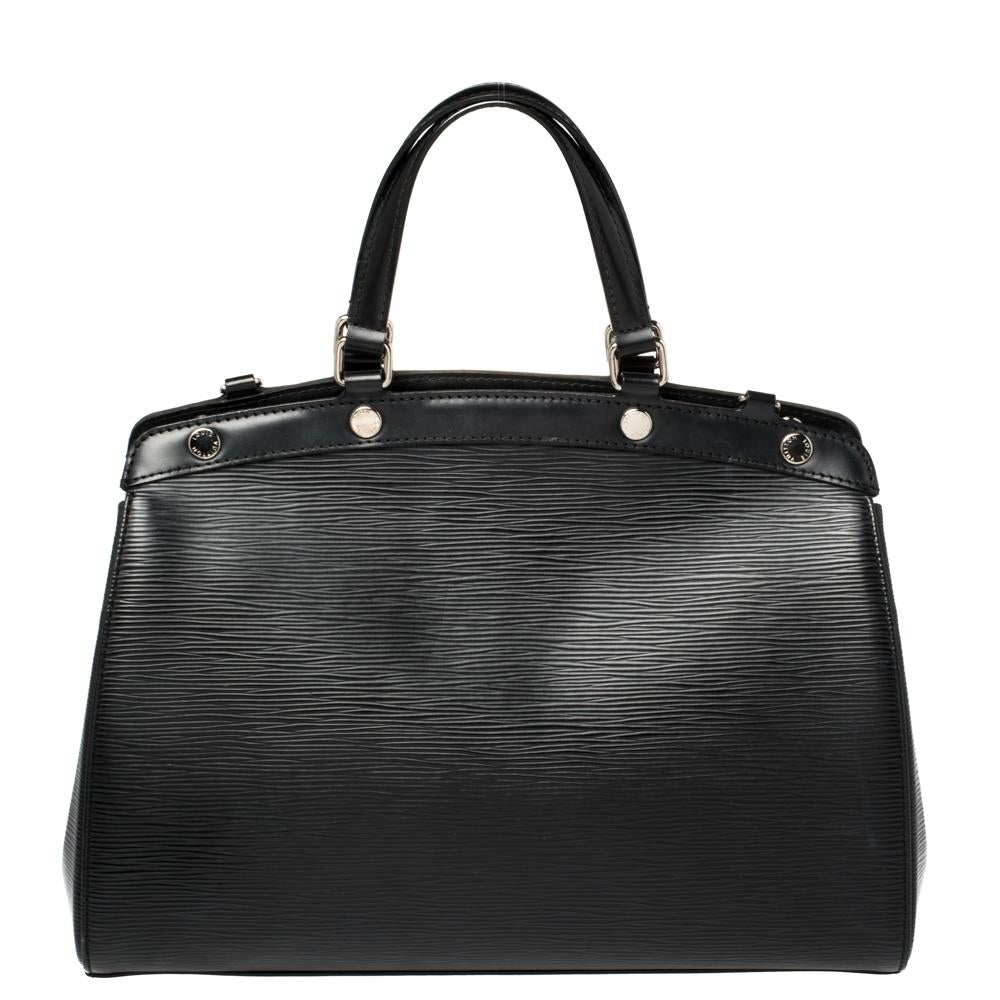 The feminine shape of Louis Vuitton's Brea is inspired by the doctor's bag. Crafted from Epi leather in black, the bag has a perfect finish. The fabric interior is spacious and it is secured by a zipper. The bag features double handles, protective