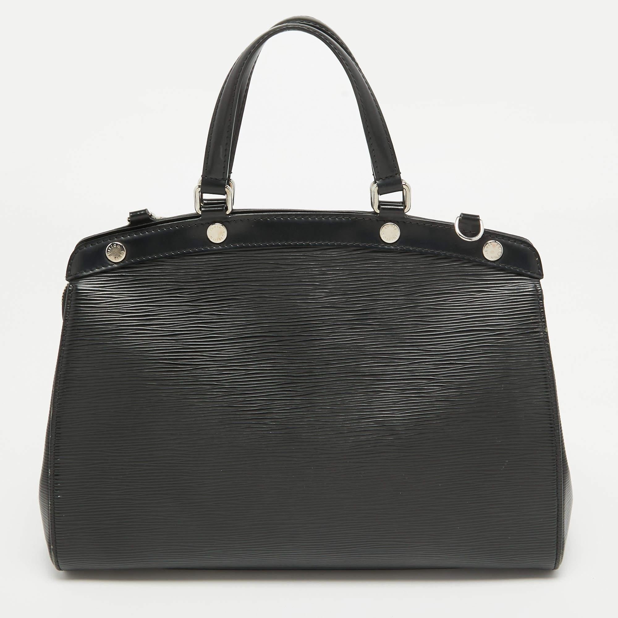 Diese Louis Vuitton Brea Tasche zeichnet sich durch ihren Glanzeffekt und ihre markante Silhouette aus. Die aus schwarzem Epi-Leder gefertigte Tasche verfügt über zwei Tragemöglichkeiten und ein geräumiges, mit Stoff gefüttertes Innenleben. Die