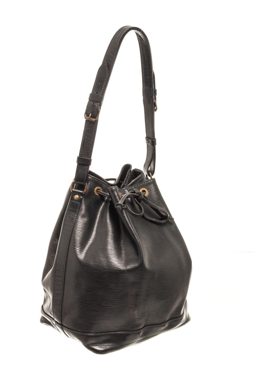 Louis Vuitton Black Epi Leather Noe GM Bucket Bag with the petit noe features an epi leather body, an adjustable shoulder strap, a drawstring closure, alcantara lining, and an interior zip pocket.

87325MSC
