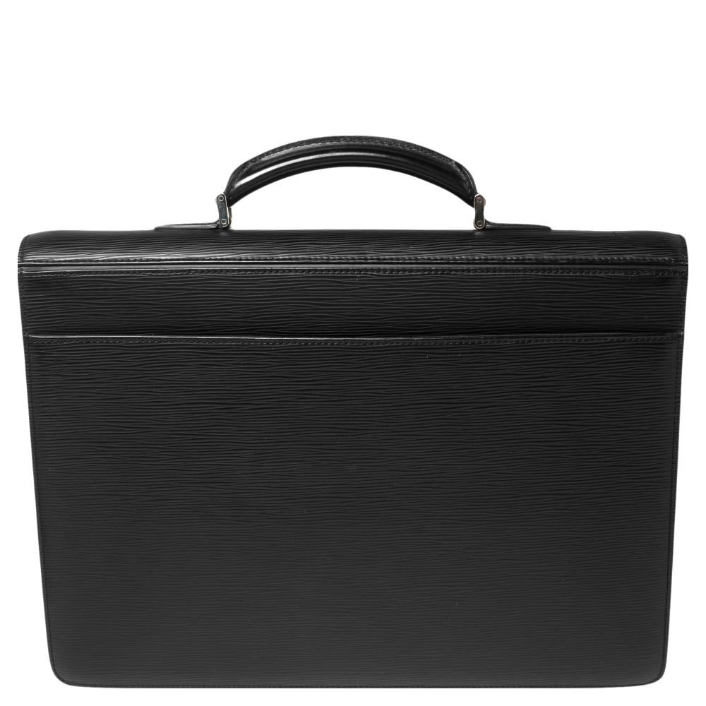 This Robusto 1 briefcase from the House of Louis Vuitton is highly functional in design and stylish in appearance. It is crafted using black Epi leather with a silver-toned lock closure attached to the front. A sturdy top handle supports this piece