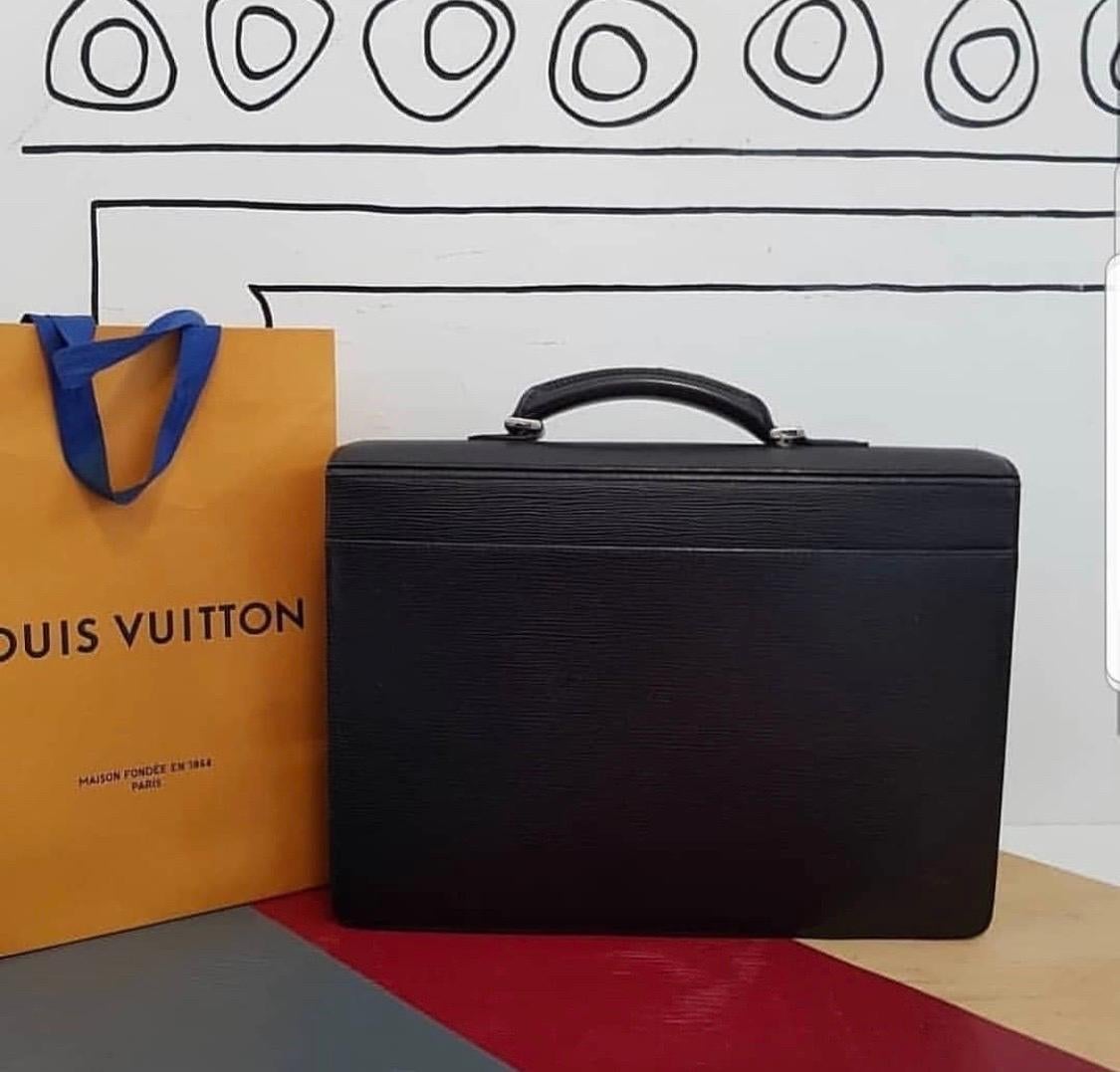 This classic briefcase from Louis Vuitton brings a whole new perspective to office repertoire. This Robusto 2 compartment briefcase is crafted from black Epi leather. The bag features subtle designing, a single top handle and a front flap with a