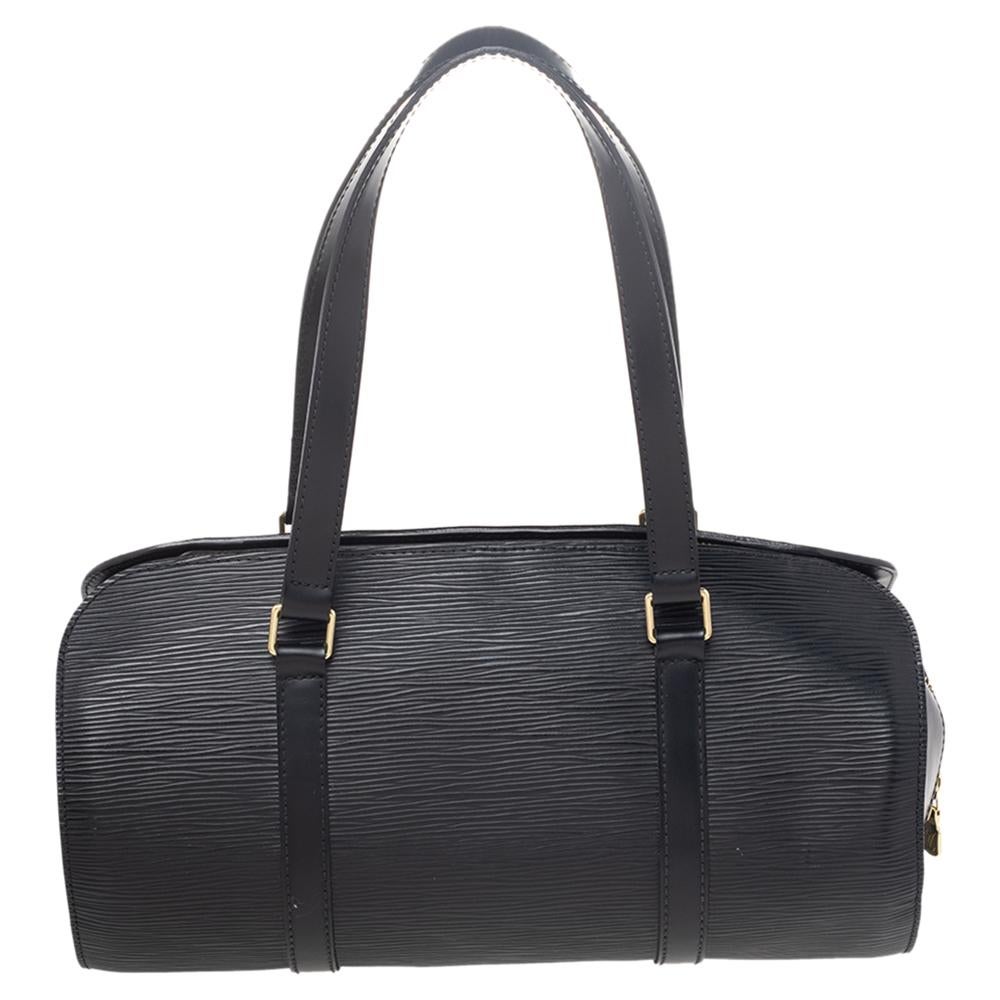 Easy to carry and chic, this Soufflot satchel by Louis Vuitton. The black epi leather exterior is accented with gold-tone hardware. This satchel features two flat leather handles and a zipper closure. The interior is lined with Alcantara and comes