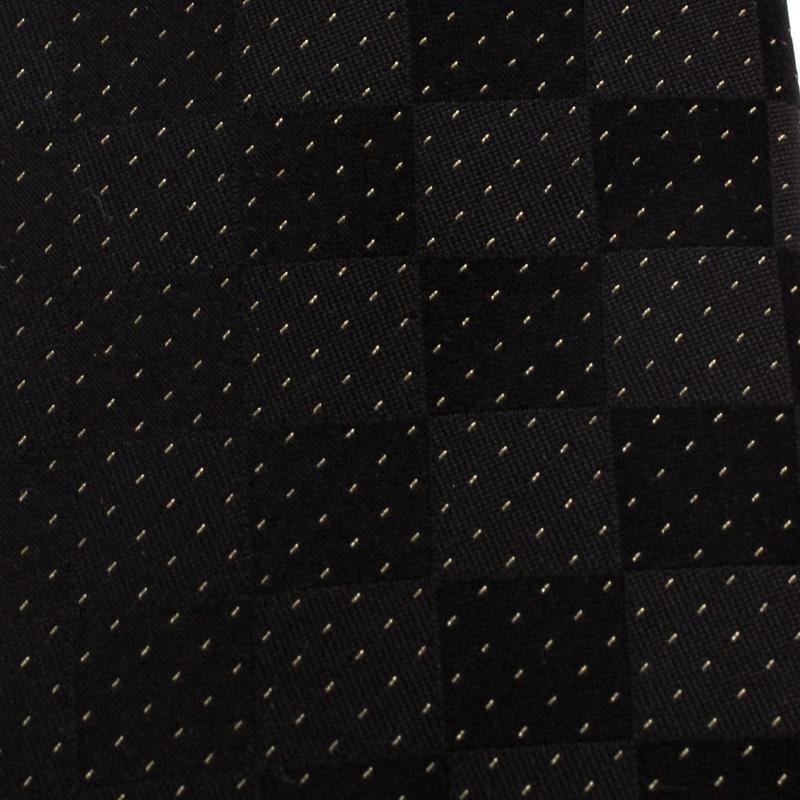 The signature Damier print on this silk tie from Louis Vuitton will lend an elegant as well as signature touch to your daytime suiting. Adorned in the shades of black and gold, the tie is tailored with a pointed tip and a keeper loop to the