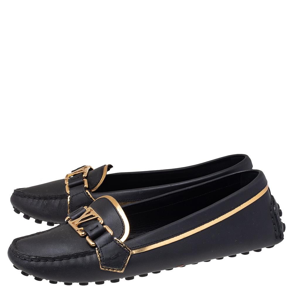 Louis Vuitton's loafers are loved by men and women worldwide as they are perfect for making a fashion statement. These black loafers are crafted from leather into a chic design and are accentuated with gold-hued trims. They flaunt round toes, LV