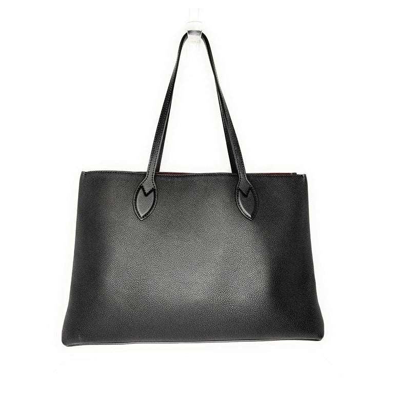 This chic tote is crafted of grained calfskin leather in black. The bag features black leather strap handles with a polished gold Louis Vuitton turn lock. This opens to a burgundy microfiber interior with a zipper compartment and a patch pocket.
