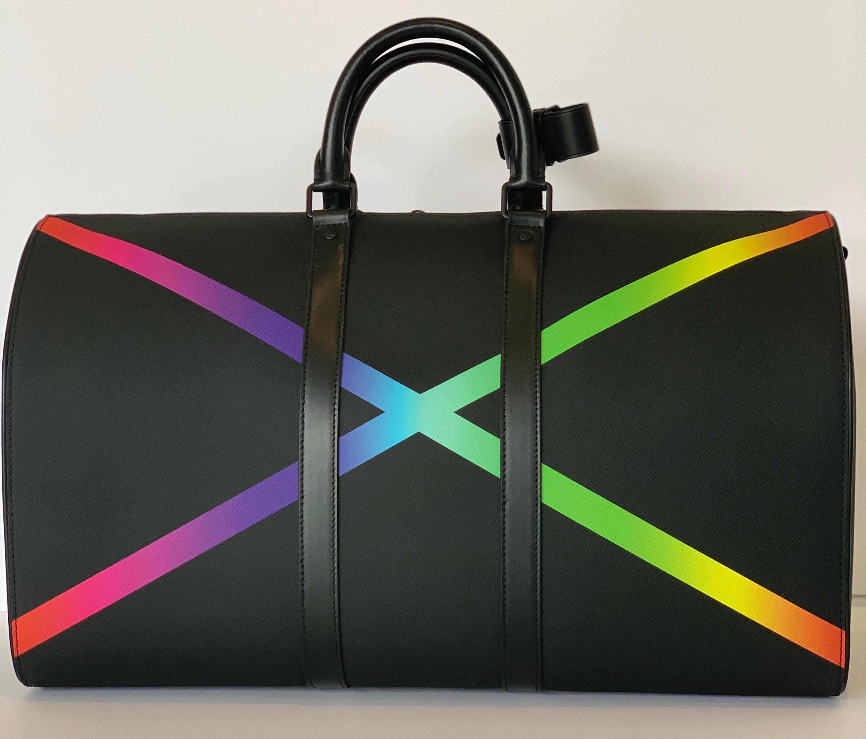 From the Virgil Abloh Collection
2019
Fashioned from mat-black Taiga leather with a soft, almost rubbery feel, the Keepall Bandoulière 50 sports a radiant “X” in rainbow colors, the visual signature for the collection from Men’s Artistic Director