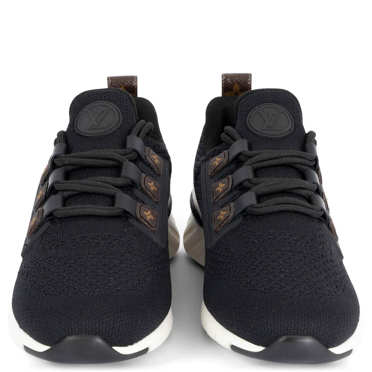 100% authentic Louis Vuitton Aftergame sneakers in black mesh embellished with signature details: a back loop in brown monogram canvas and brown rubber monogram flower inserts for the laces. The white outsole is embossed with the emblematic
