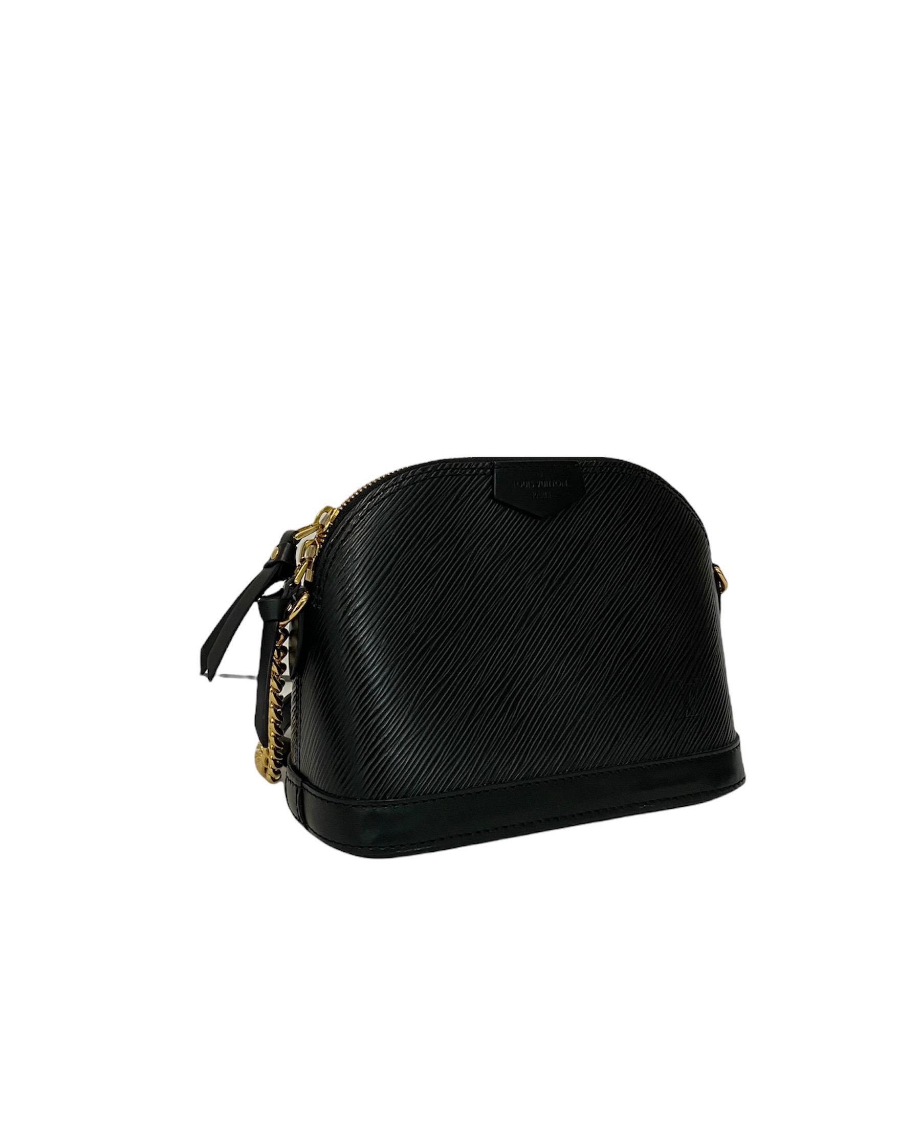 Louis Vuitton Alma bag size PM in black Epi leather with golden hardware. It has a central opening with zip closure. The interior is lined with a black suede and is equipped with a side pocket. In addition, it is equipped with a shoulder strap in