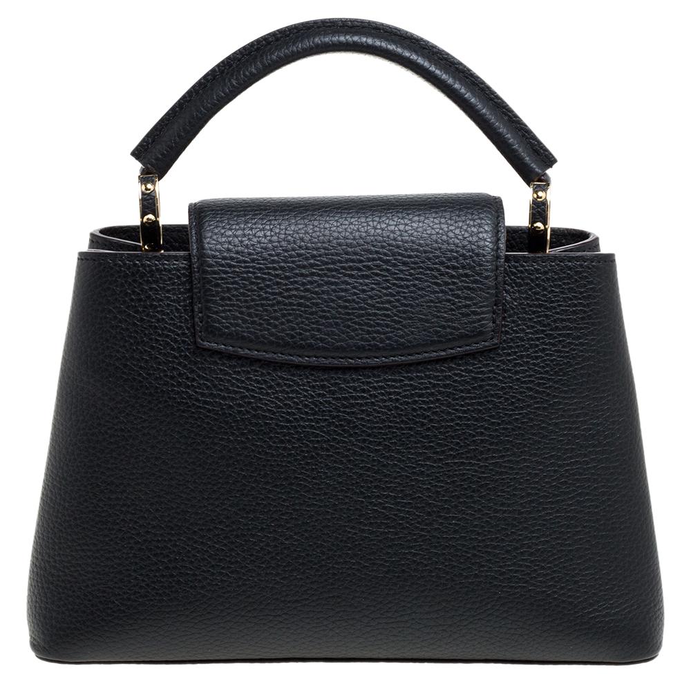 It is every woman's dream to own a Louis Vuitton handbag as appealing as this one. Crafted from leather, this bag features a structured design with a single handle and protective metal feet. While the front LV elevates its beauty, the leather