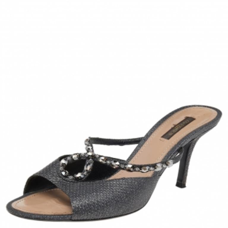 Charm your way to all your social gatherings in this pair of slide sandals from Louis Vuitton. Crafted from black leather, they carry a smart design with open toes, embellishments on the vamps, and sturdy heels. Comfortable insoles make them a pair