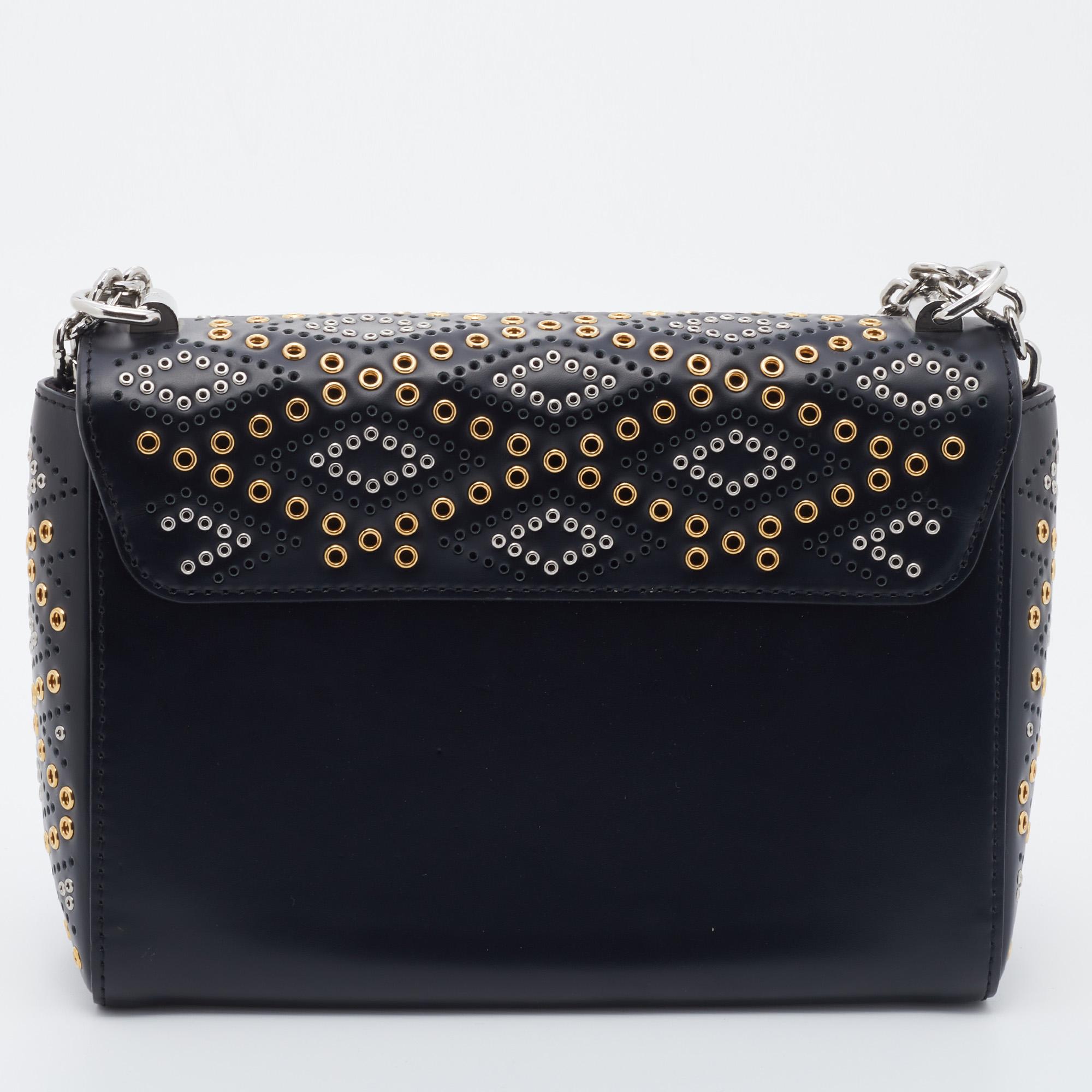 Crafted from leather, this LV bag features a structured design with a sleek strap that can be used as a crossbody or hung on the shoulder. While the black shade and grommet embellishments elevate its beauty, the Alcantara-lined interior will