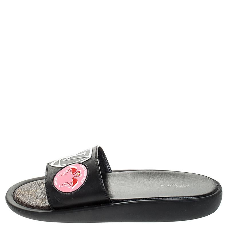 Comfort, luxury, and high-fashion come combined in these black slides from Louis Vuitton! They are designed with a rubber base and decorated with patches of LV and flamingo on the leather uppers. The slides are made for your casual style and for