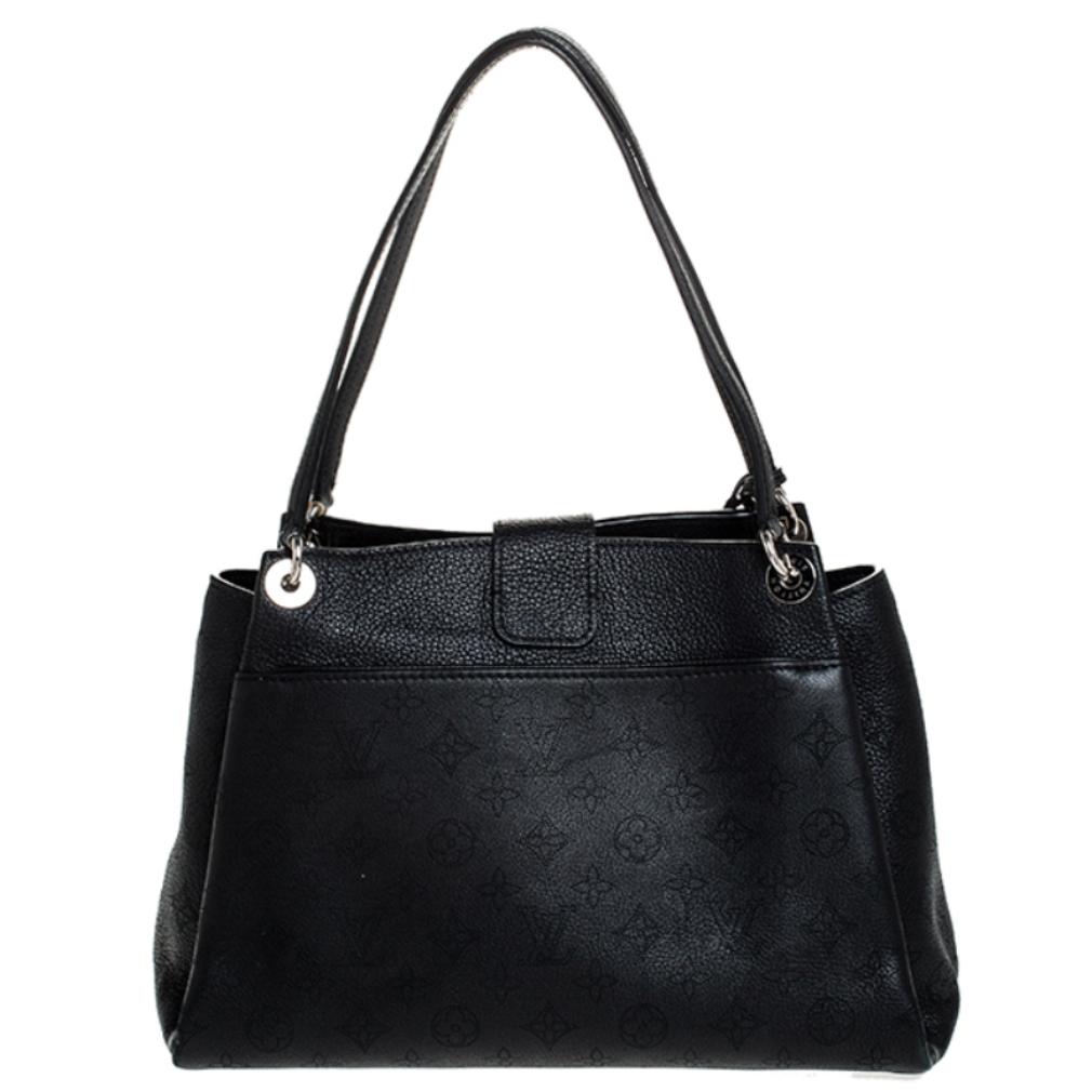 Louis Vuitton handbags are every fashionista's dream come true. This bag is crafted in France and made of Mahina leather. It features the brand's signature throughout and comes in a classic shade of black. The bag is held by dual handles, has a