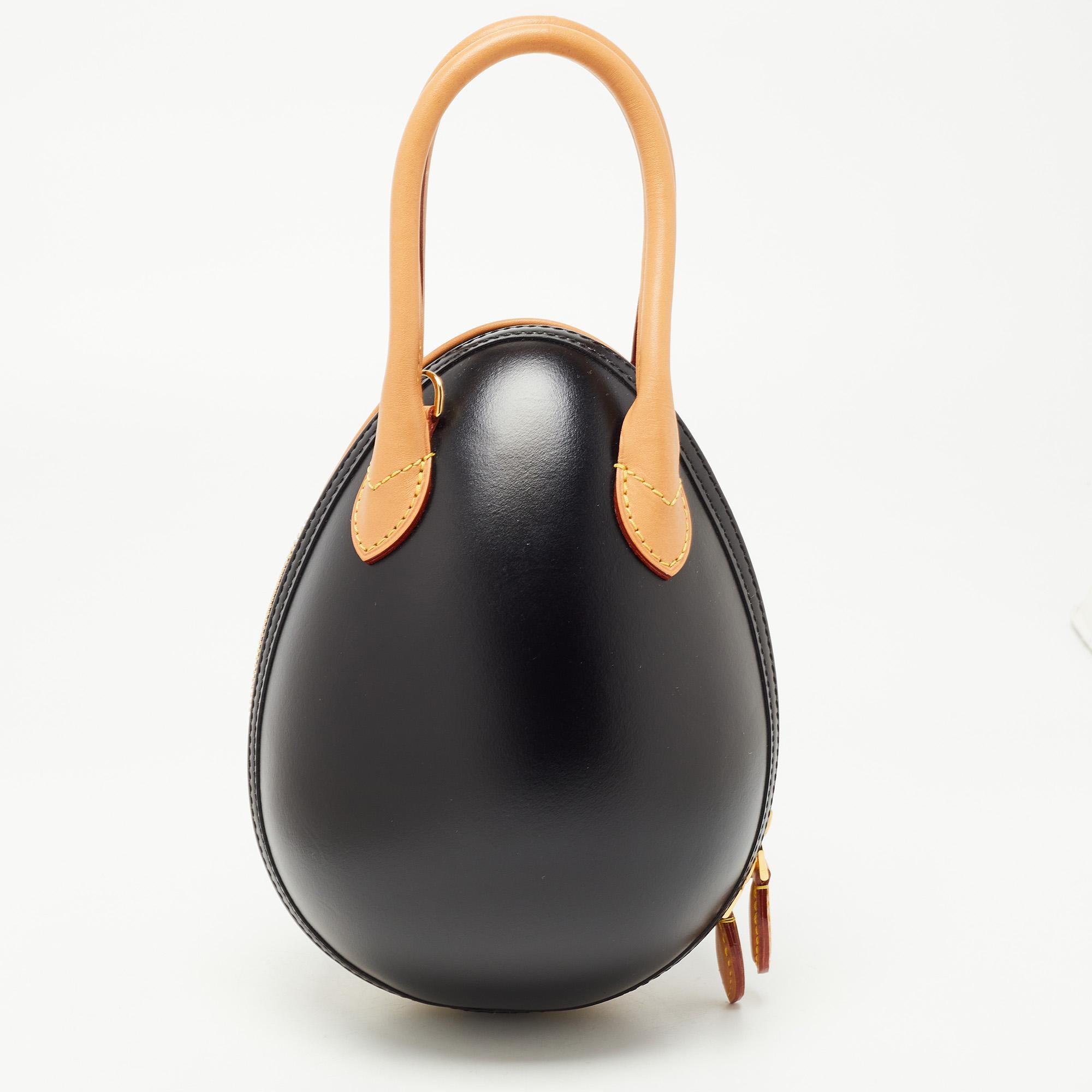 This Louis Vuitton handbag is an example of the brand's fine designs blended finely with the latest trends in fashion. This LV Egg bag has a signature touch with the iconic monogram canvas and tan leather construction, while the playful egg shape