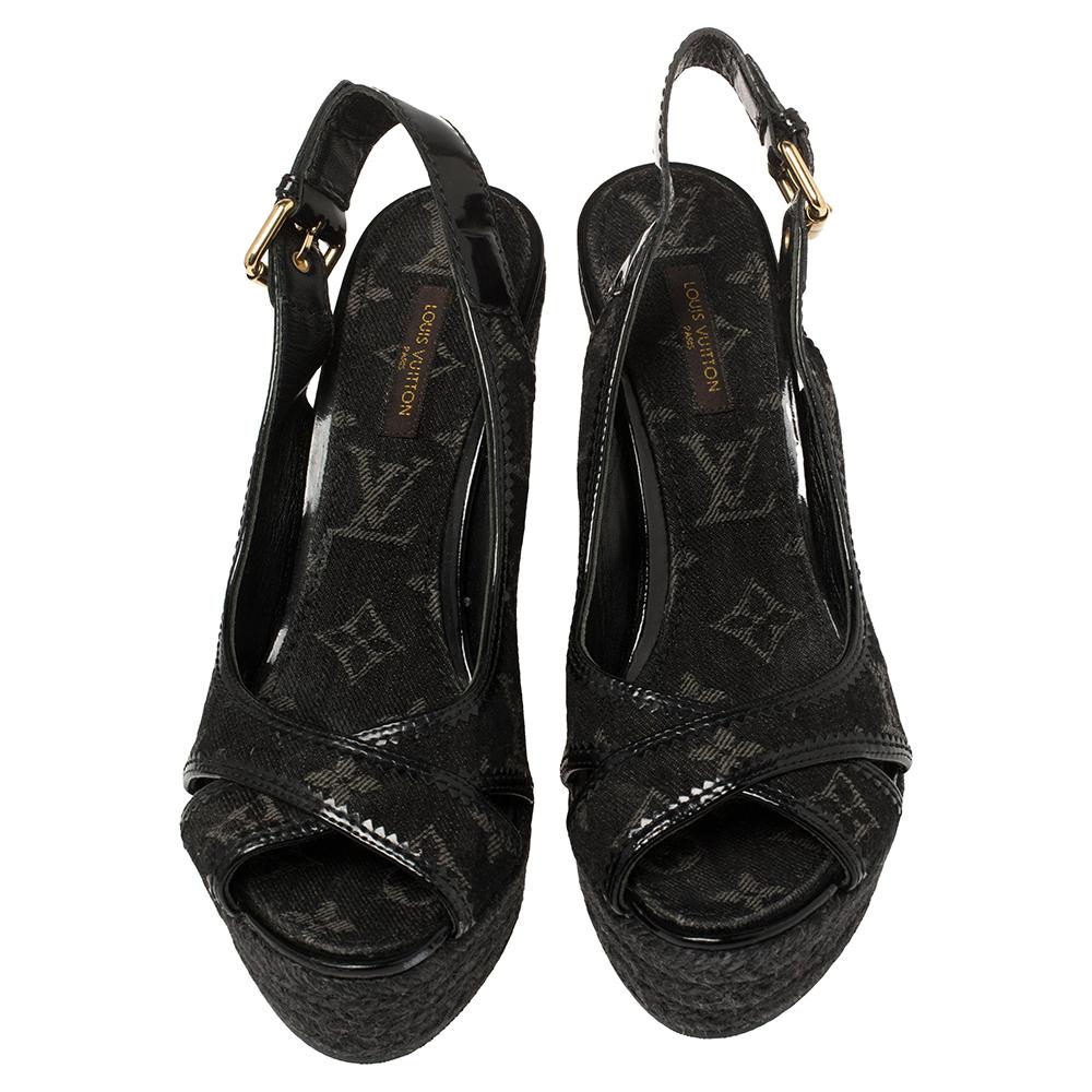 These black monogram denim and patent leather sandals from Louis Vuitton have been designed to lift your style. They flaunt open toes, cross vamp straps, slingbacks with buckle fastening, and 11.5 cm espadrille wedge heels. Pair them with a jumpsuit