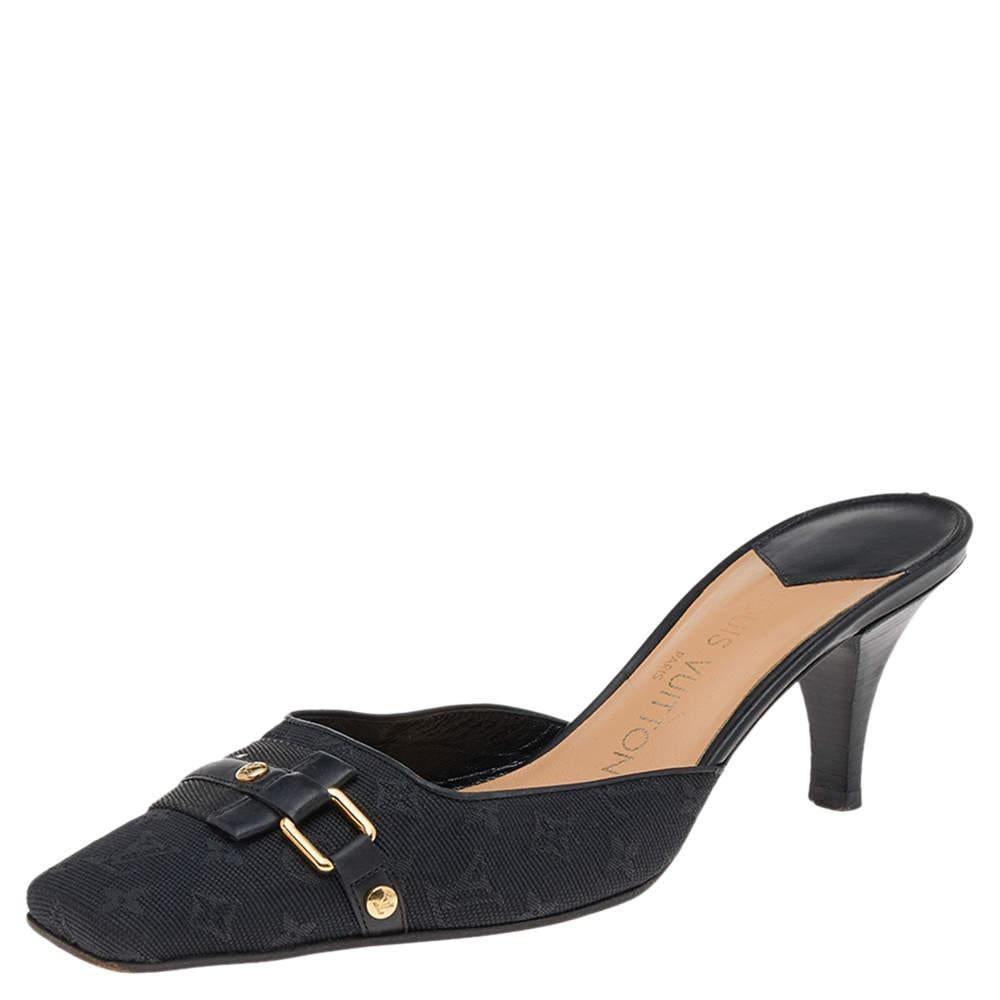 Simplicity and comfort take center stage in these black mules from Louis Vuitton! They have been crafted from monogram-embossed canvas and mounted on low heels. They come added with gold-tone hardware and comfortable leather-lined insoles.