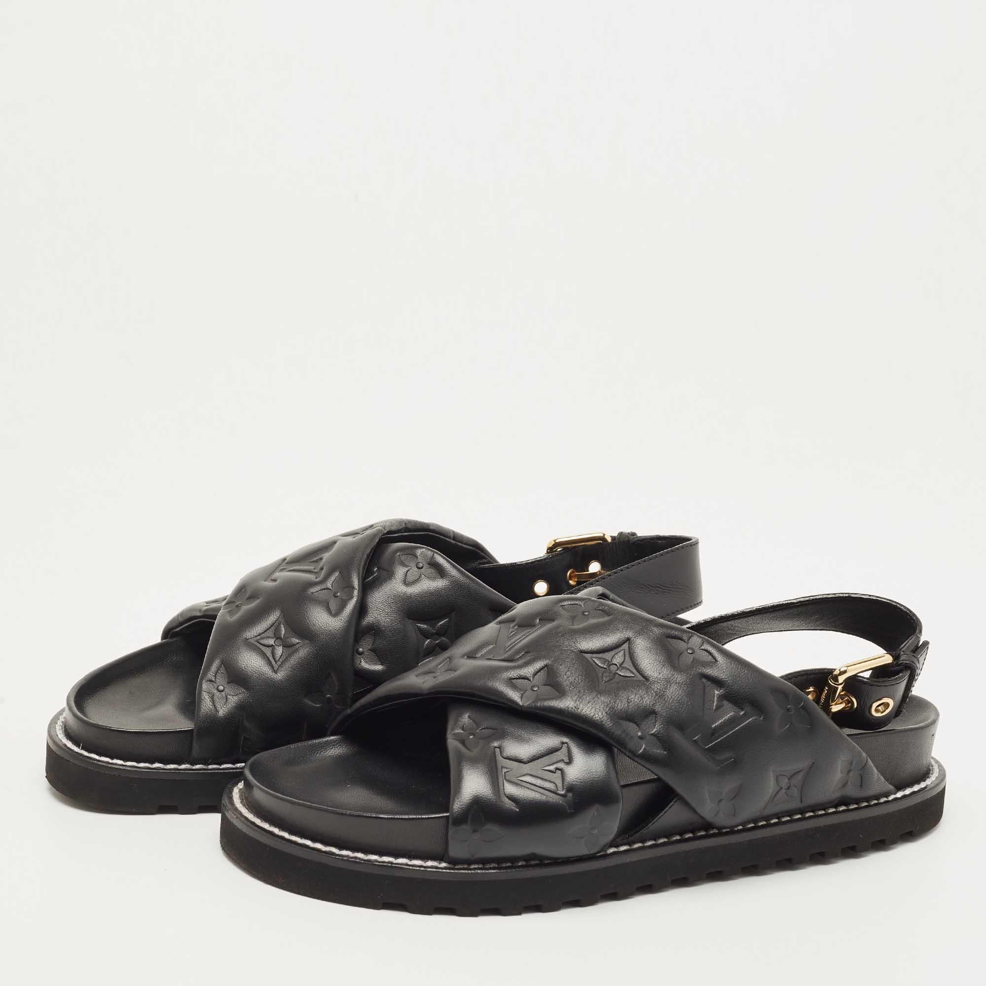The Louis Vuitton Paseo flats are exquisite footwear, featuring the iconic LV monogram pattern embossed onto black leather. These elegant sandals offer comfort and style with a flat sole and a sleek, minimalist design, making them a luxurious
