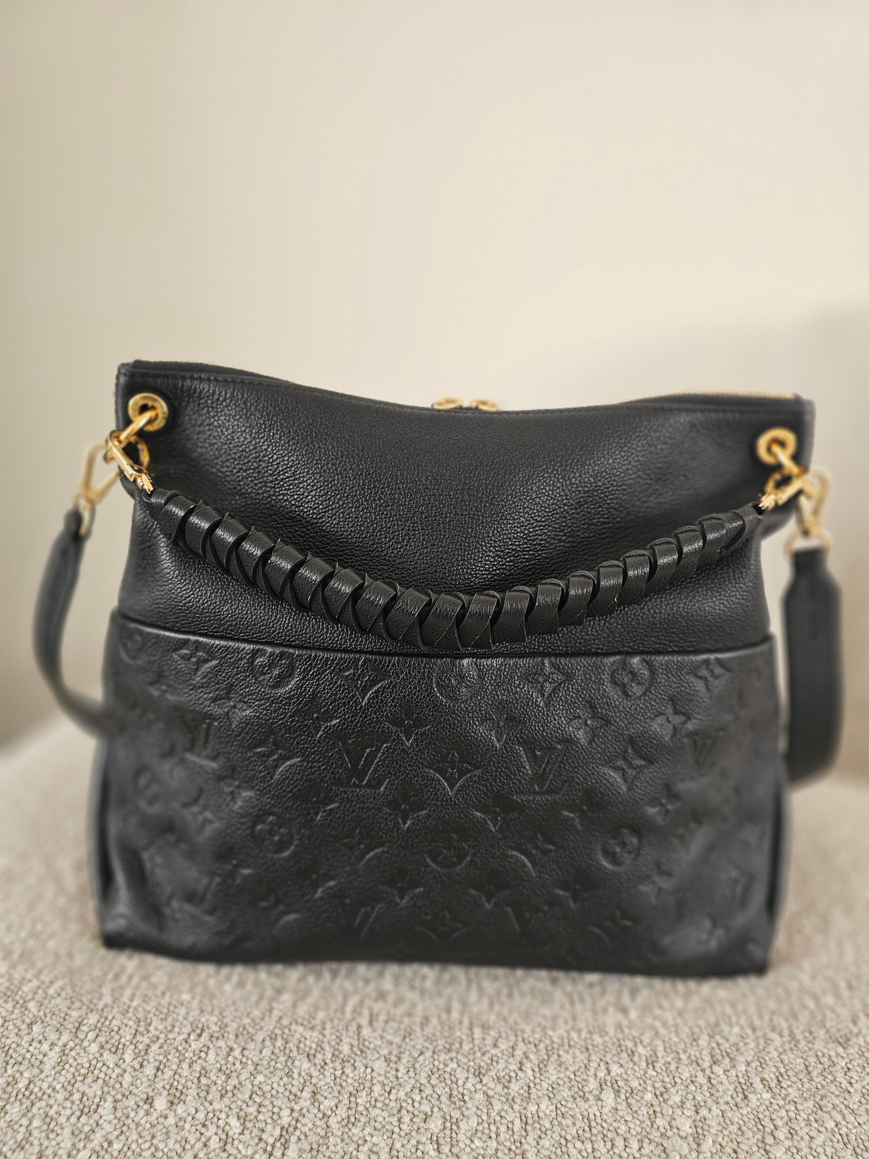 The Louis Vuitton Maida Hobo Bag in black Monogram Empreinte leather is an elegant and functional handbag that was introduced in 2020 as part of the brand’s Fall/Winter collection. This bag combines style with practicality and is designed for