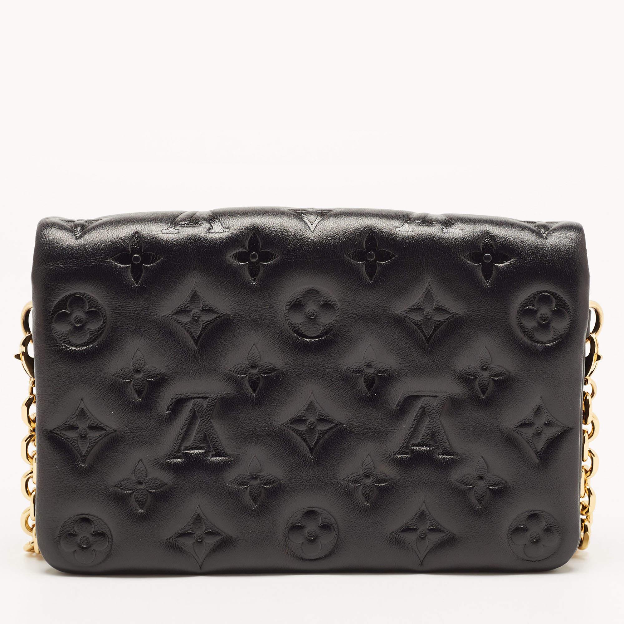 Louis Vuitton pochette Coussin is a monogram-laden accessory that is accompanied by a chain for shoulder or crossbody wear. This one here in black leather has a puffy exterior, an Alcantara interior, and gold-tone hardware.

Includes: Original