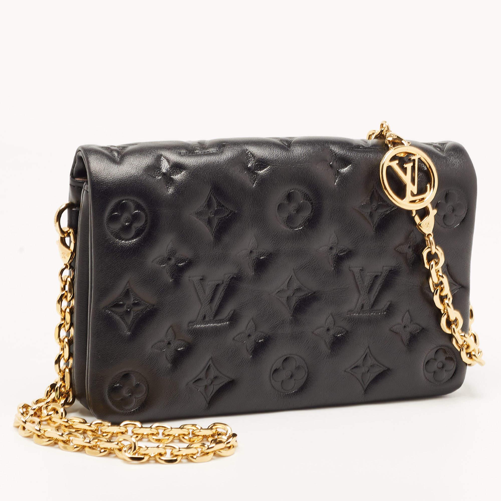 Louis Vuitton pochette Coussin is a monogram-laden accessory that is accompanied by a chain for shoulder or crossbody wear. This one here in black leather has a puffy exterior, an Alcantara interior, and gold-tone hardware.

