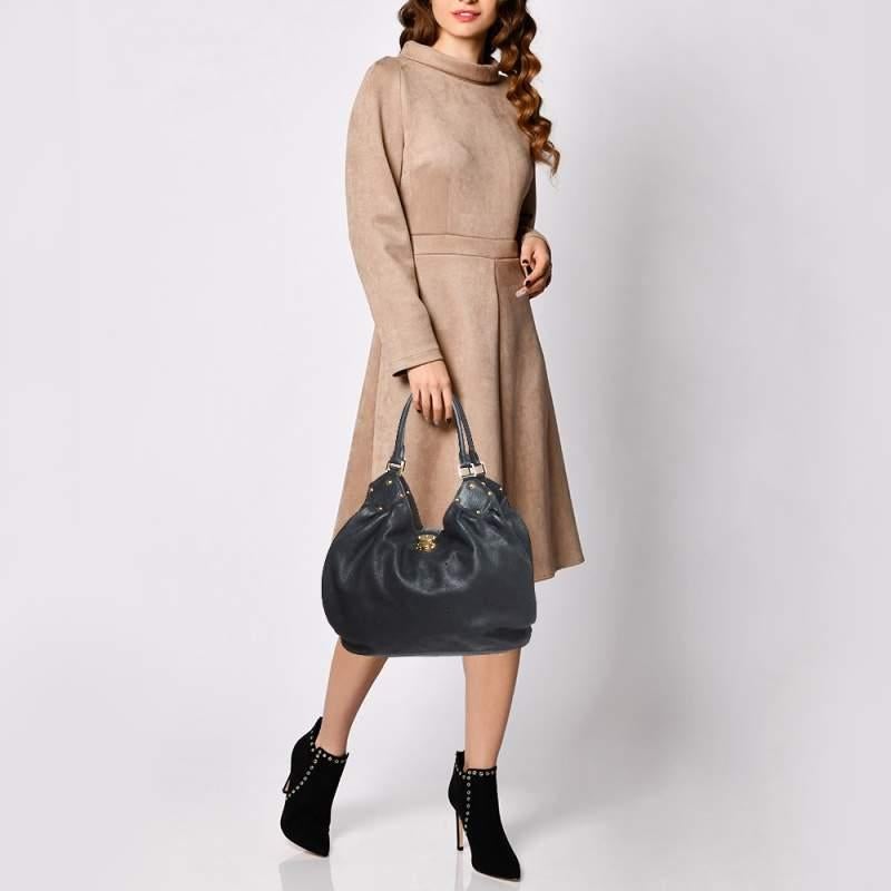 This bag from the house of Louis Vuitton is a delight to own. Louis Vuitton's Mahina collection was inspired by the crescents of the moon. Featuring a slightly slouchy silhouette the bag comes with dual rolled top handles, buckle detailing on the