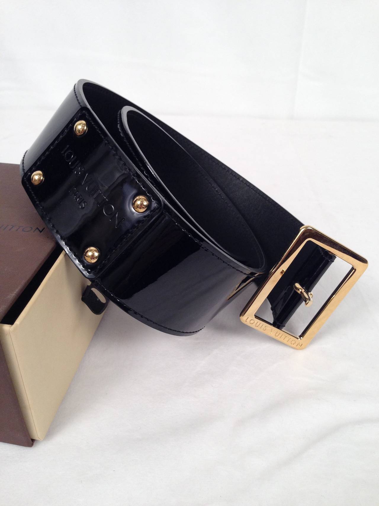 Black but NOT Basic belt from Louis Vuitton!  Luxurious patent leather and gold tone hardware bearing the Louis Vuitton logo makes a lasting impression.  Features rear rectangular patent patch anchored by gold studs bearing the world-famous logo. 