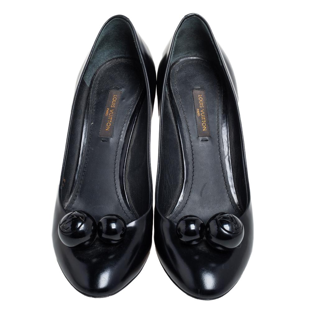 These lovely pumps from Louis Vuitton are an ideal choice as they are stylish and comfortable. They are made of black patent leather and designed with round embellishments on the vamps. This delicate pair is perfect for parties and work. The pumps