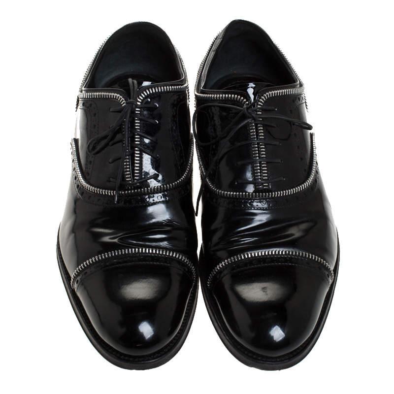 A perfect combination classy and bold style, these stunning Louis Vuitton oxfords are a must have for men who don't shy from flaunting something exclusive. Constructed in black patent leather and accented with silver-tone chain trims, these shoes