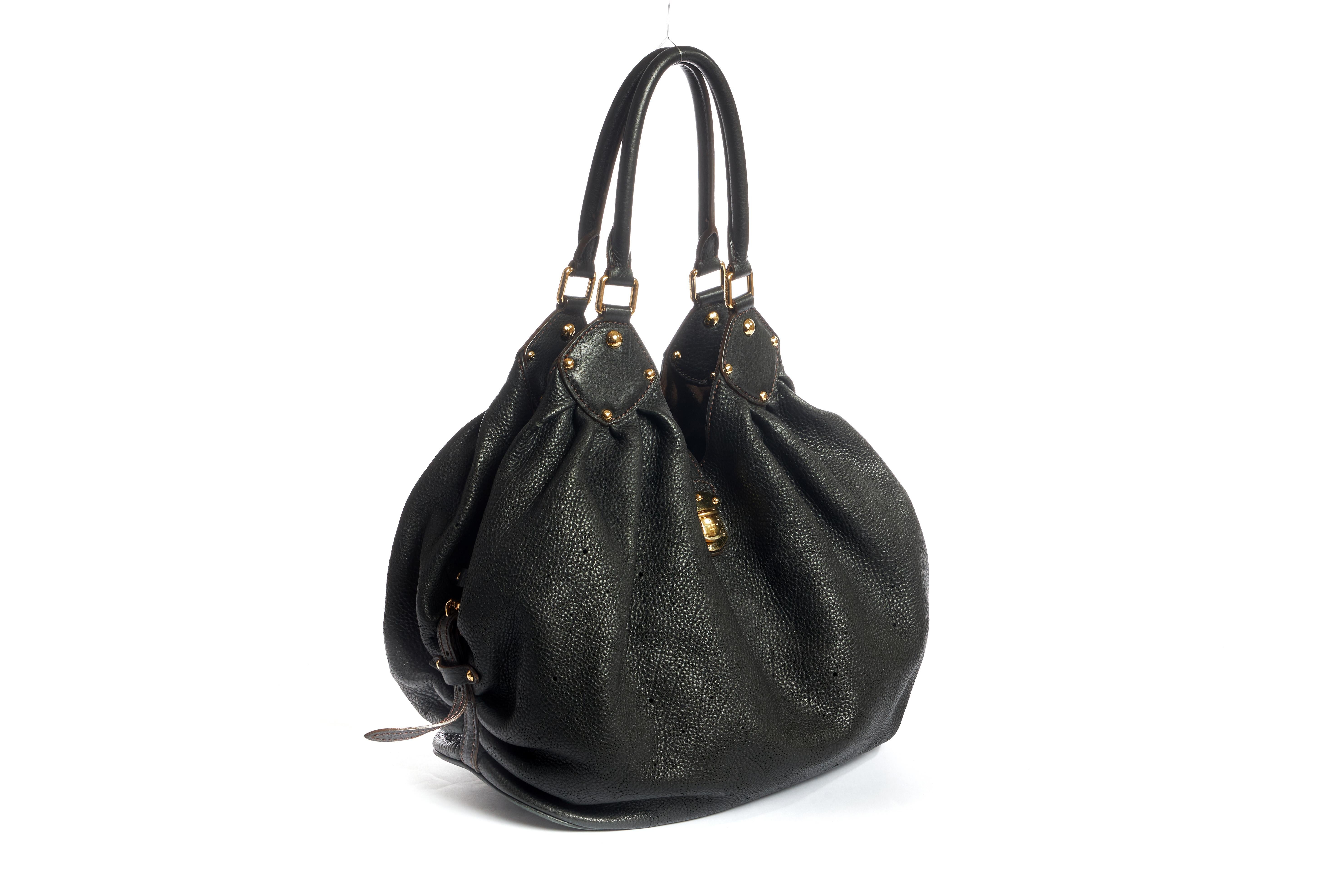 Grand sac mahina en cuir noir perforé Louis Vuitton. La doublure intérieure présente une certaine usure. Epaule de 10
