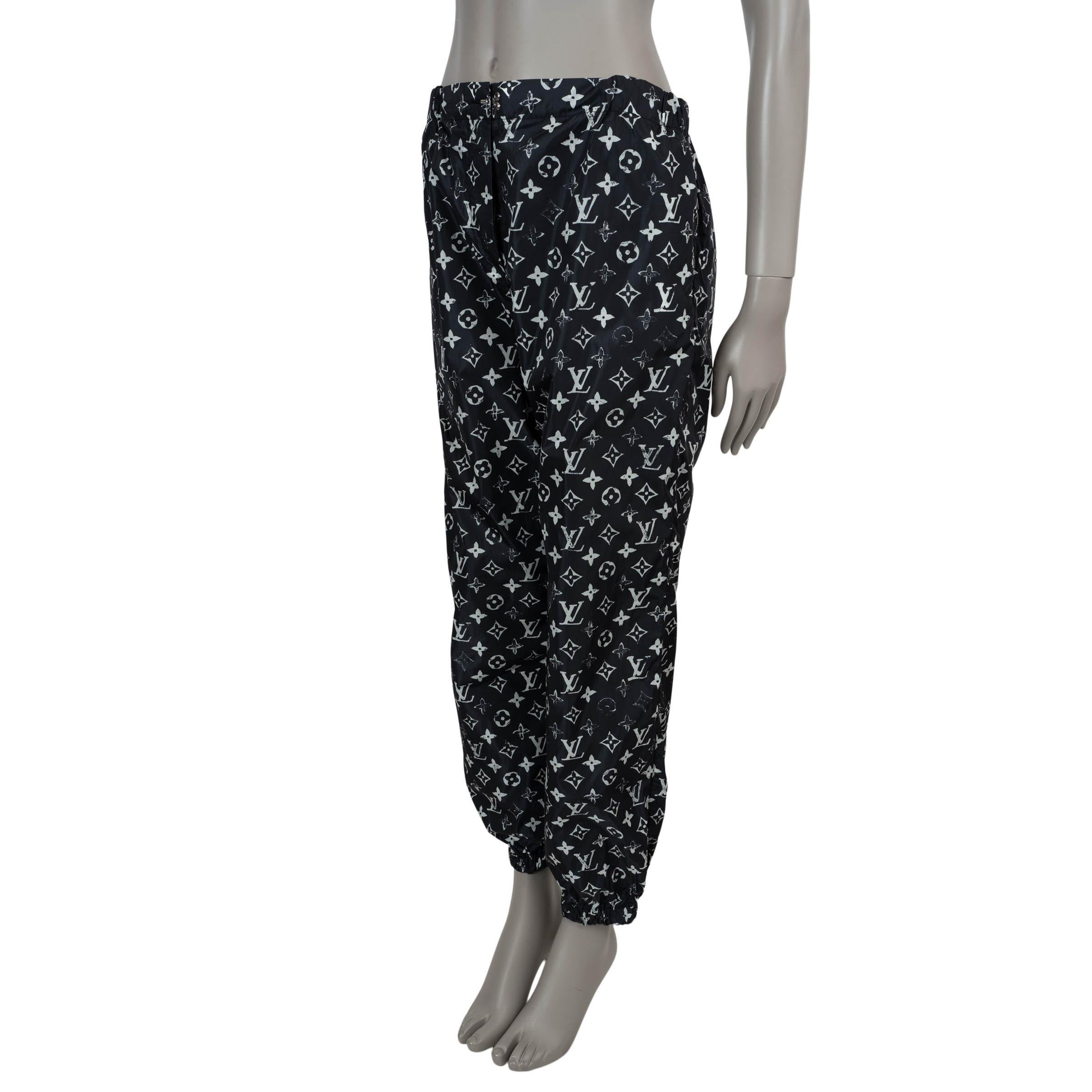 Diese 100% authentische Louis Vuitton Jogginghose aus schwarzem Polyamid (100%) bietet eine elegante Mischung aus Luxus und sportlichem Stil. Sie sind mit einem weißen Monogram-Druck in Schablonenoptik verziert und haben eine klassische Passform mit